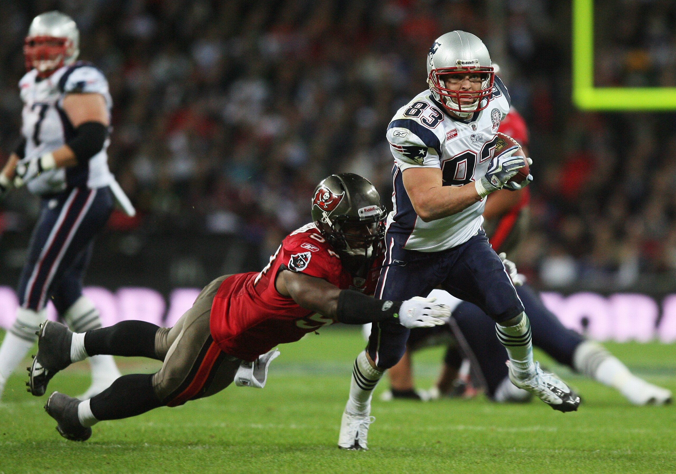 LONDON, ENGLAND - OCTOBER 25: Wes Welker (#83) of the New England Patriots is tackled by Adam Hayward (#57) of Tampa Bay Buccaneers during the NFL International Series match between New England Patriots and Tampa Bay Buccaneers at Wembley Stadium on Octo LONDON, ENGLAND - OCTOBER 25: Wes Welker (#83) of the New England Patriots is tackled by Adam Hayward (#57) of Tampa Bay Buccaneers during the NFL International Series match between New England Patriots and Tampa Bay Buccaneers at Wembley Stadium on Octo