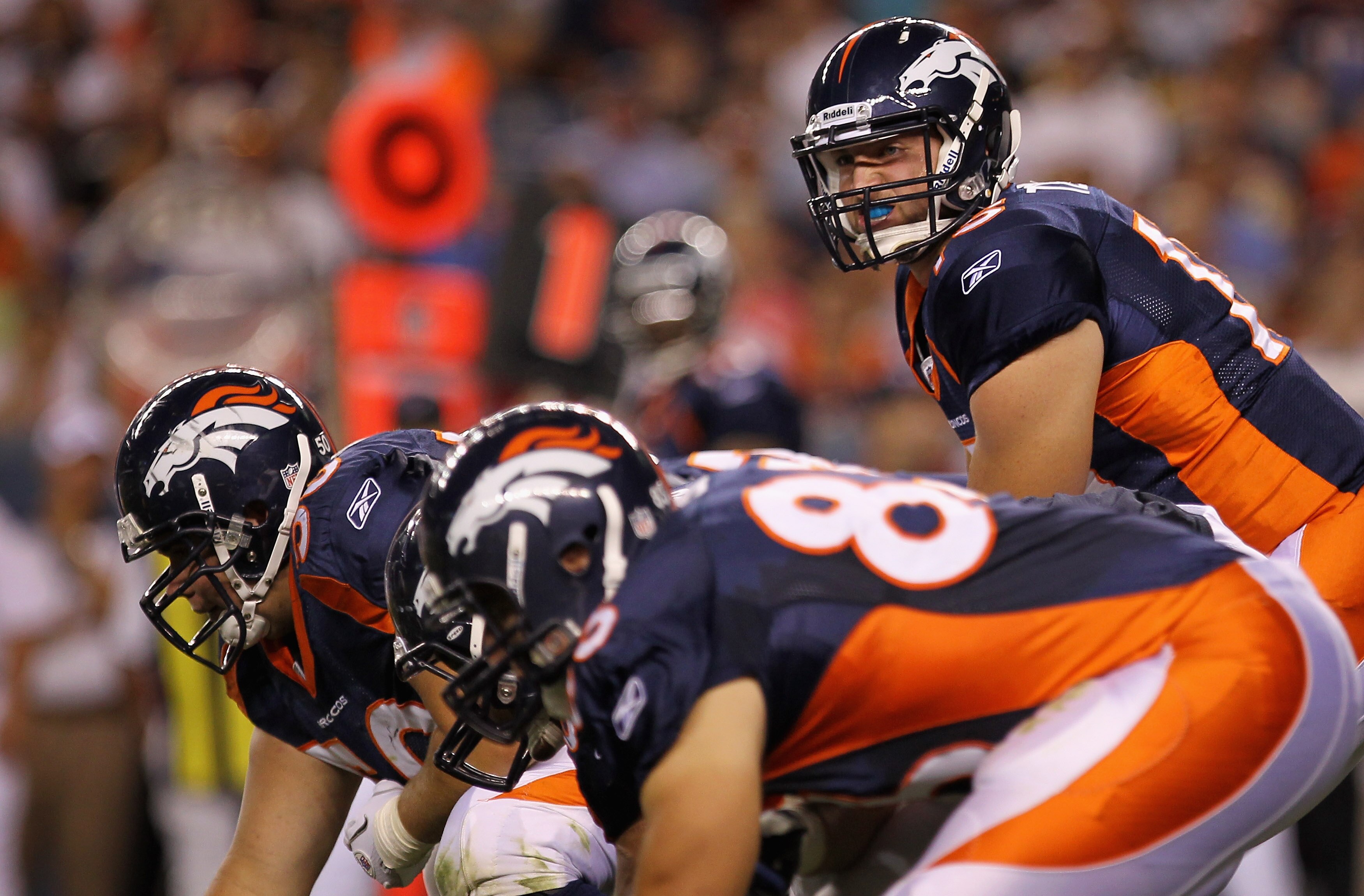DENVER - AUGUST 29:  Quarterback Tim Tebow #15 of the Denver Broncos lines up over center J.D. Walton #50 and prepares to take the snap against the Pittsburgh Steelers during preseason NFL action at INVESCO Field at Mile High on August 29, 2010 in Denver,