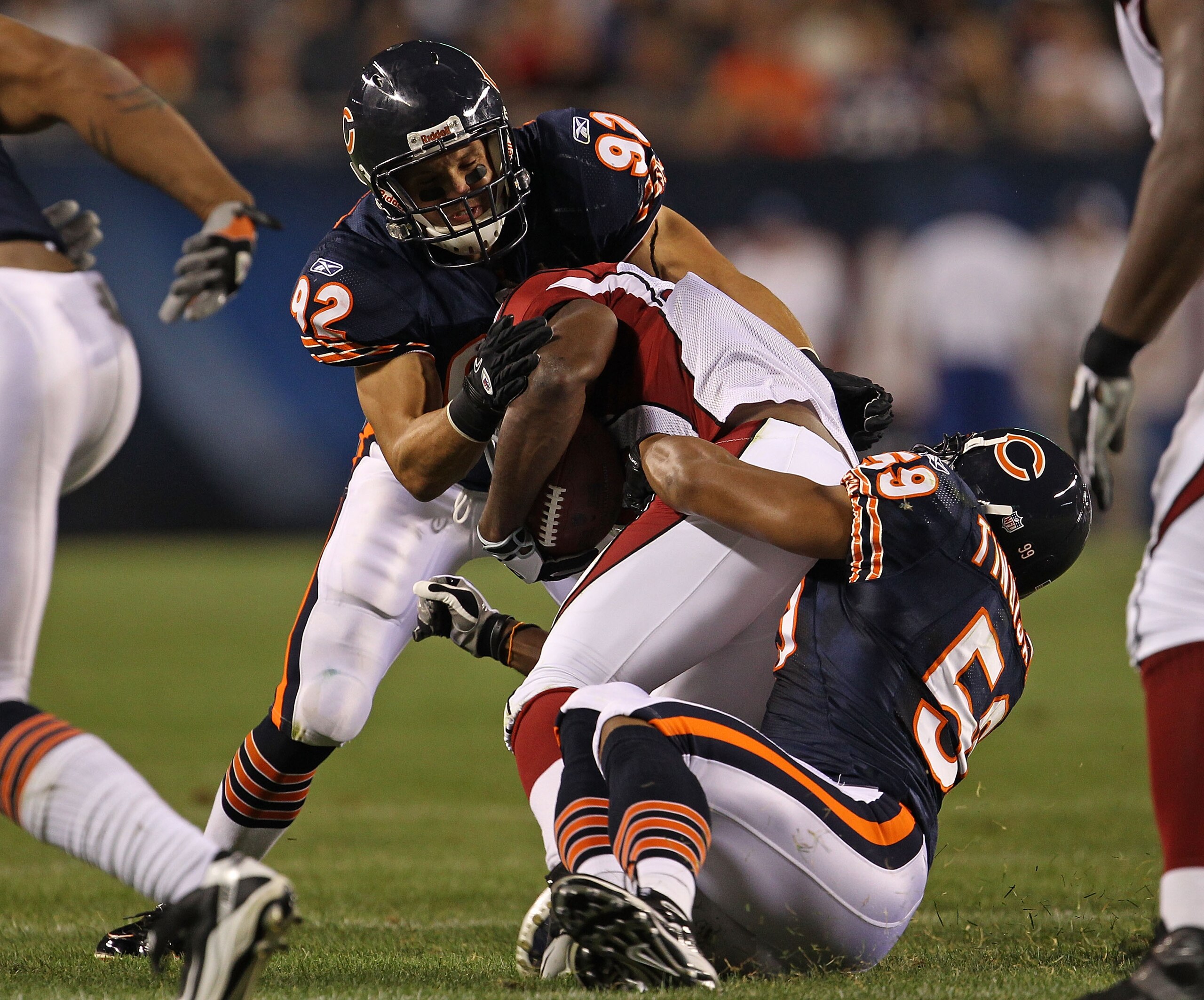 CHICAGO - AUGUST 28: Hunter Hillenmeyer #92 and Pisa Tinoisamoa #59 of the Chicago Bears tackle Tim Hightower #34 of the Arizona Cardinals during a preseason game at Soldier Field on August 28, 2010 in Chicago, Illinois. The Cardinals defeated the Bears 1