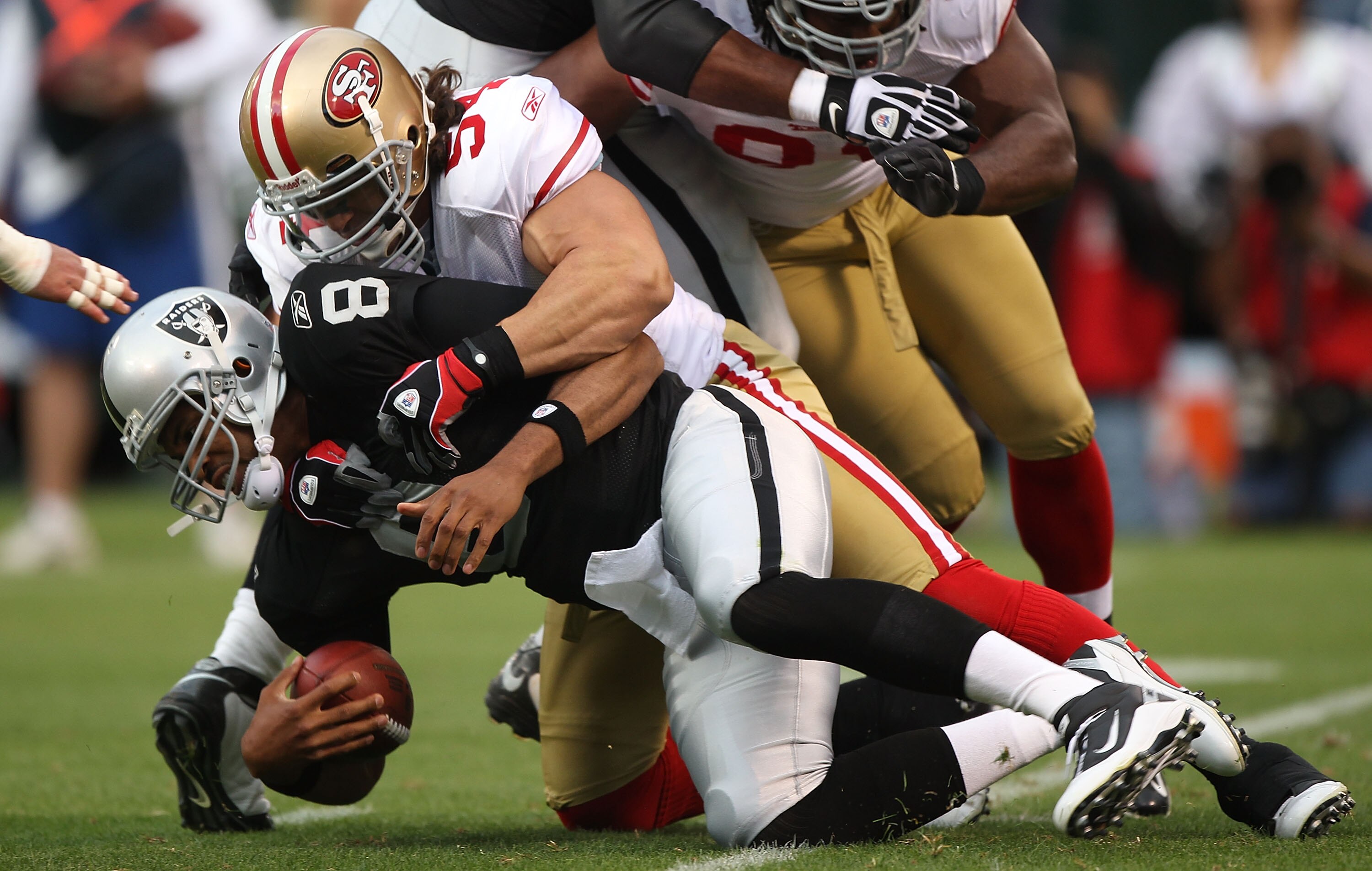 OAKLAND, CA - AUGUST 28:  Jason Campbell #8 of the Oakland Raiders is sacked by Travis LaBoy #54 of the San Francisco 49ers during an NFL preseason game at Oakland-Alameda County Coliseum on August 28, 2010 in Oakland, California. (Photo by Jed Jacobsohn/