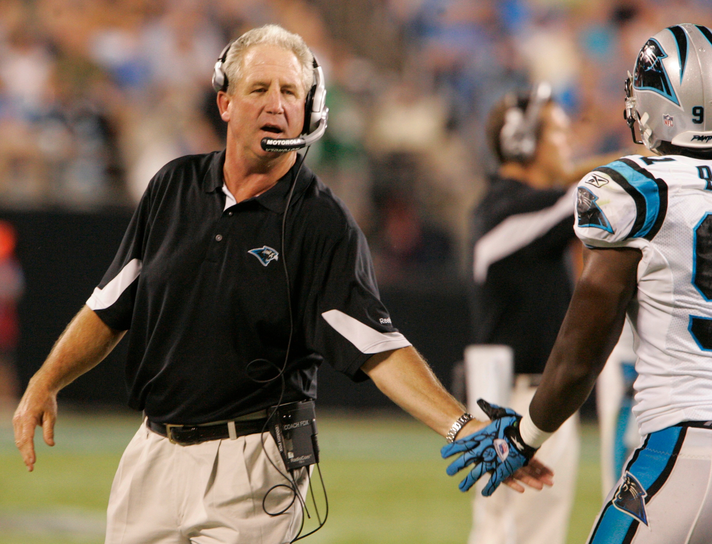 CHARLOTTE, NC - AUGUST 21:  John Fox of the Carolina Panthers shakes hand with Defensive End Everett Brown #91as they come off the field during their preseason game against the New York Jets at Bank of America Stadium on August 21, 2010 in Charlotte, Nort