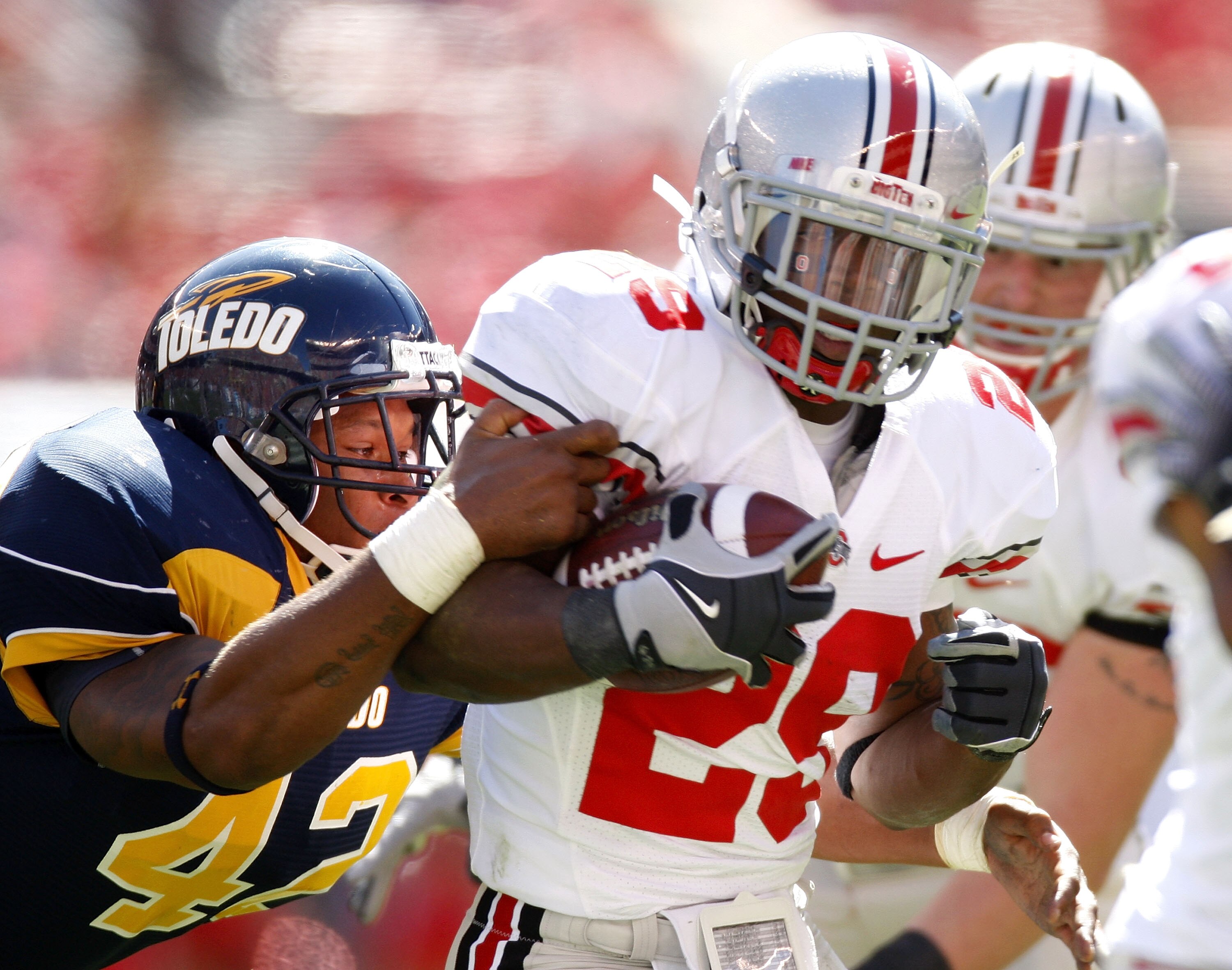 CLEVELAND - SEPTEMBER 19:  Jordan Hall #29 of the Ohio State Buckeyes tries to get around the tackle of Archie Donald #42 of the Toledeo Rockets on September 19, 2009 at Cleveland Browns Stadium in Cleveland, Ohio. Ohio State won the game 38-0.  (Photo by