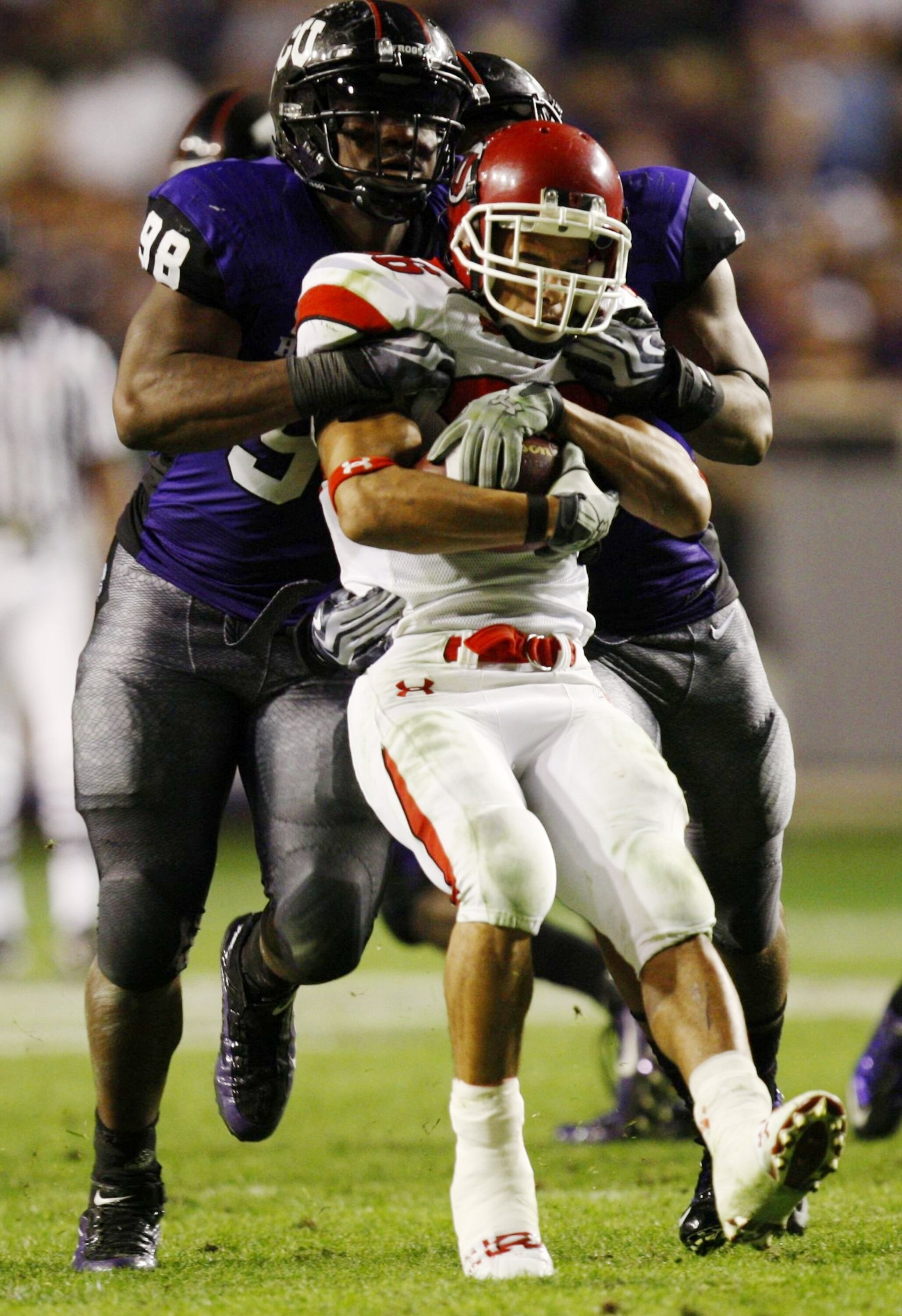 FORT WORTH, TX - NOVEMBER 14:  Eddie Wide #36 of the Utah Utes is tackled by Jerry Hughes #98 of the TCU Horned Frogs during the second half of the game at Amon G. Carter Stadium on November 14, 2009 in Fort Worth, Texas. TCU won the game 55-28. (Photo by