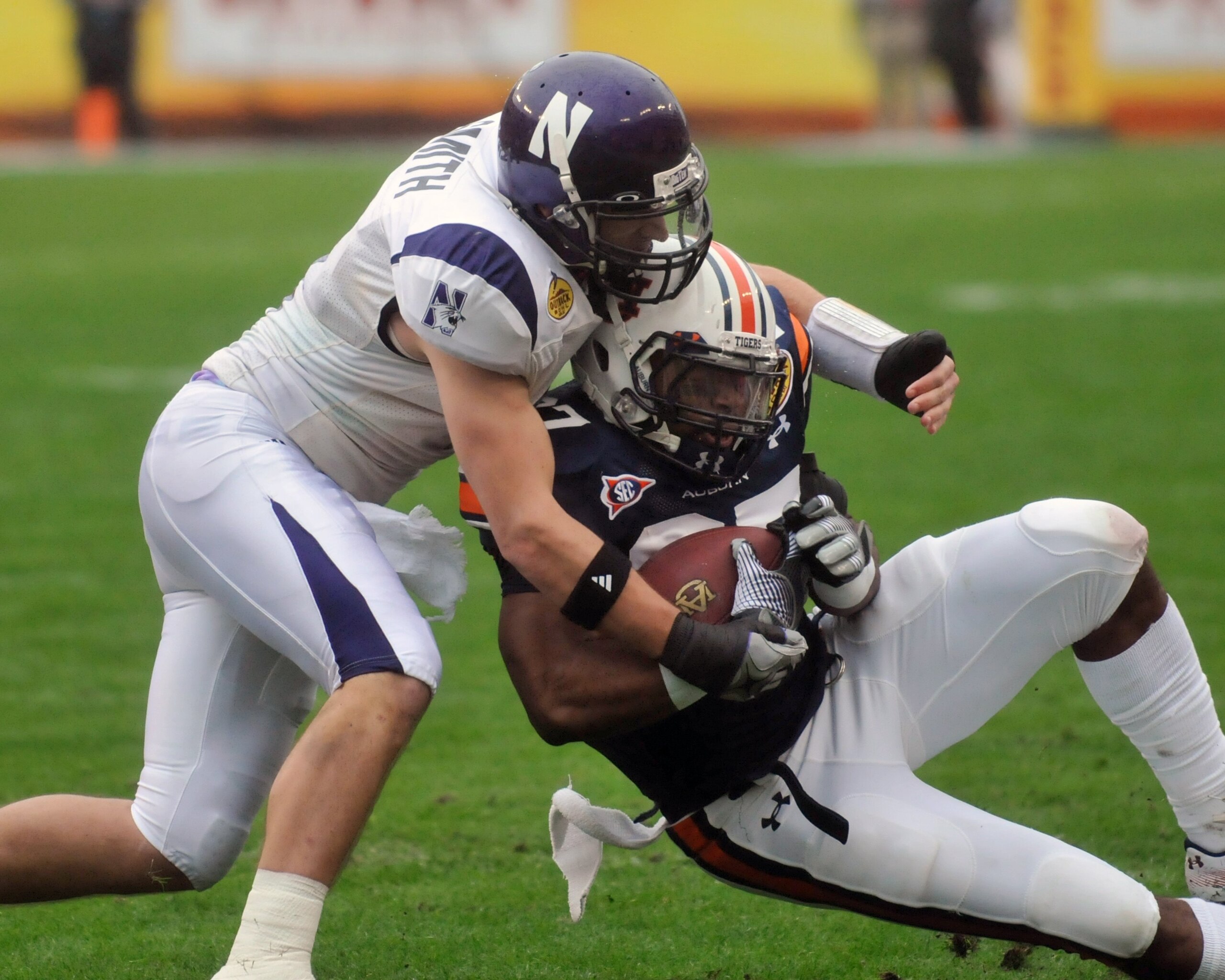 TAMPA, FL - JANUARY 1: Safety Brendan Smith #4 of the Northwestern Wildcats tackles running back Marion Fannin #27 of the Auburn Tigers in the Outback Bowl January 1, 2010 at Raymond James Stadium in Tampa, Florida. (Photo by Al Messerschmidt/Getty Imag TAMPA, FL - JANUARY 1: Safety Brendan Smith #4 of the Northwestern Wildcats tackles running back Marion Fannin #27 of the Auburn Tigers in the Outback Bowl January 1, 2010 at Raymond James Stadium in Tampa, Florida. (Photo by Al Messerschmidt/Getty Imag