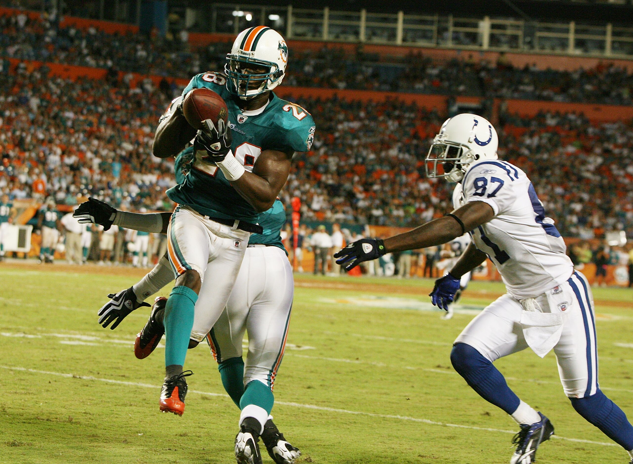 MIAMI - SEPTEMBER 21:  Wide receiver Reggie Wayne #87 of the Indianapolis Colts watches as safety Gibril Wilson #28 of the Miami Dolphins tries to grab an interception at Land Shark Stadium on September 21, 2009 in Miami, Florida. After being called an in