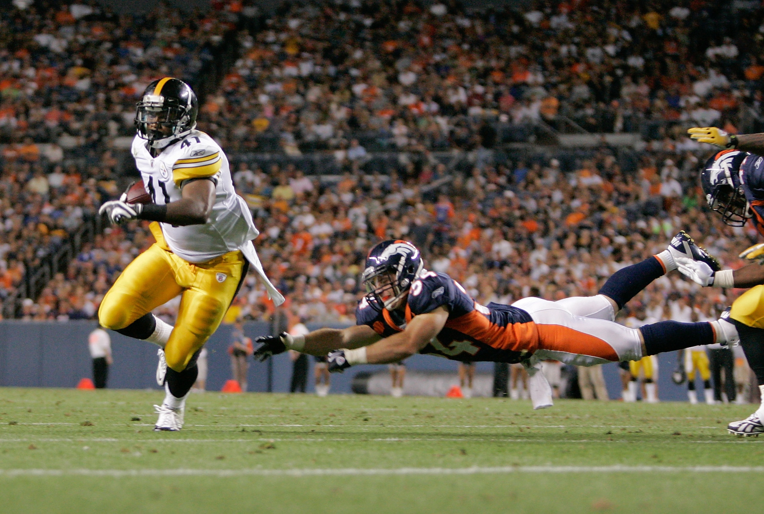 DENVER - AUGUST 29: Running back Jonathan Dwyer #41 of the Pittsburgh Steelers avoids a diving tackle by safety Kyle McCarthy #34 of the Denver Broncos and scores a touchdown in the fourth quarter at INVESCO Field at Mile High on August 29, 2010 in Denver DENVER - AUGUST 29: Running back Jonathan Dwyer #41 of the Pittsburgh Steelers avoids a diving tackle by safety Kyle McCarthy #34 of the Denver Broncos and scores a touchdown in the fourth quarter at INVESCO Field at Mile High on August 29, 2010 in Denver