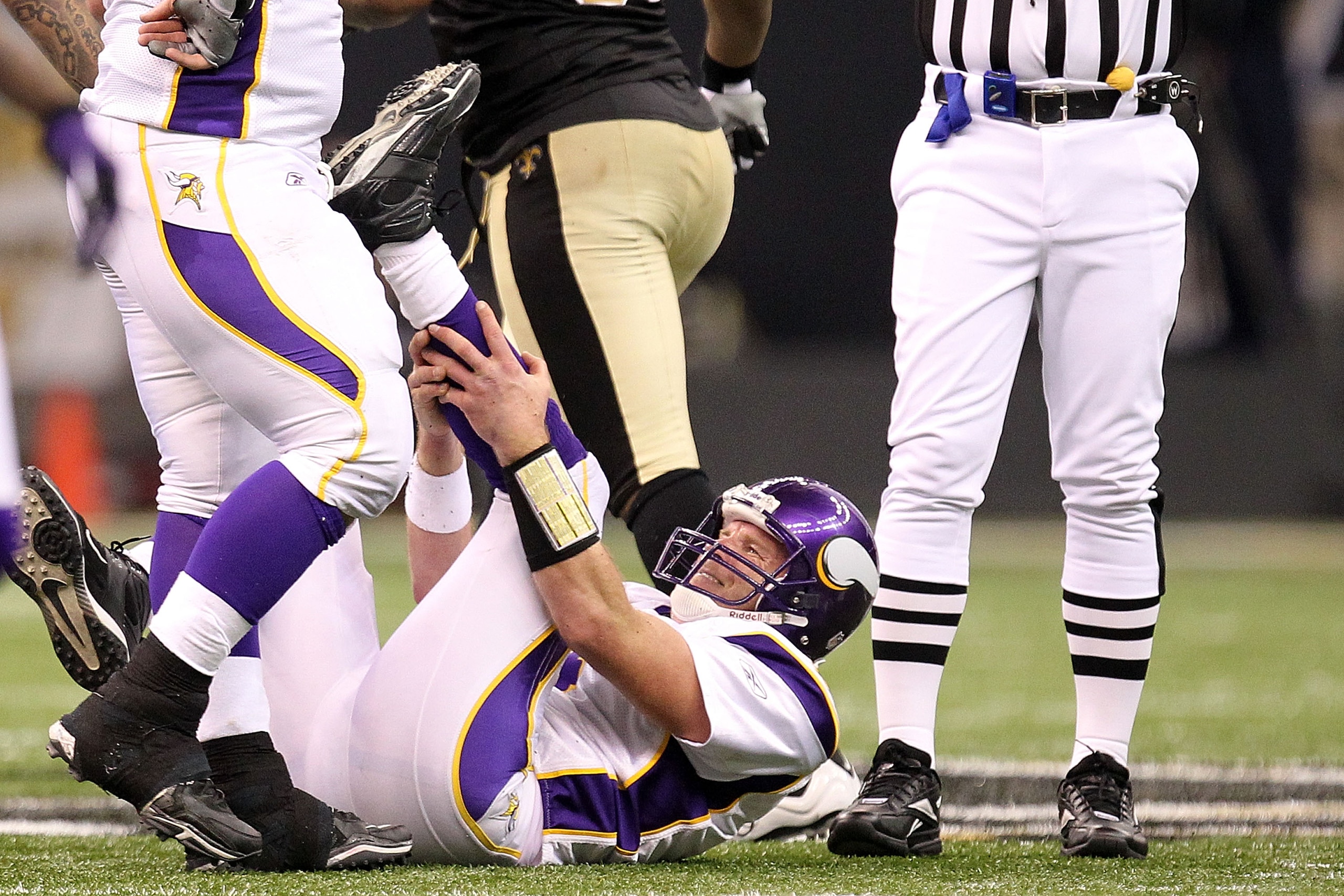NEW ORLEANS - JANUARY 24:  Brett Favre #4 of  the Minnesota Vikings grabs his ankle after taking a hard hit in the second half against the New Orleans Saints during the NFC Championship Game at the Louisiana Superdome on January 24, 2010 in New Orleans, L