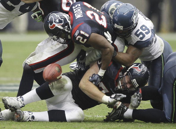 HOUSTON - DECEMBER 13:  Running back Ryan Moats #21 of the Houston Texans has the ball stripped from behind by linebacker  Aaron Curry #59 of the Seattle Seahawks at Reliant Stadium on December 13, 2009 in Houston, Texas.  (Photo by Bob Levey/Getty Images