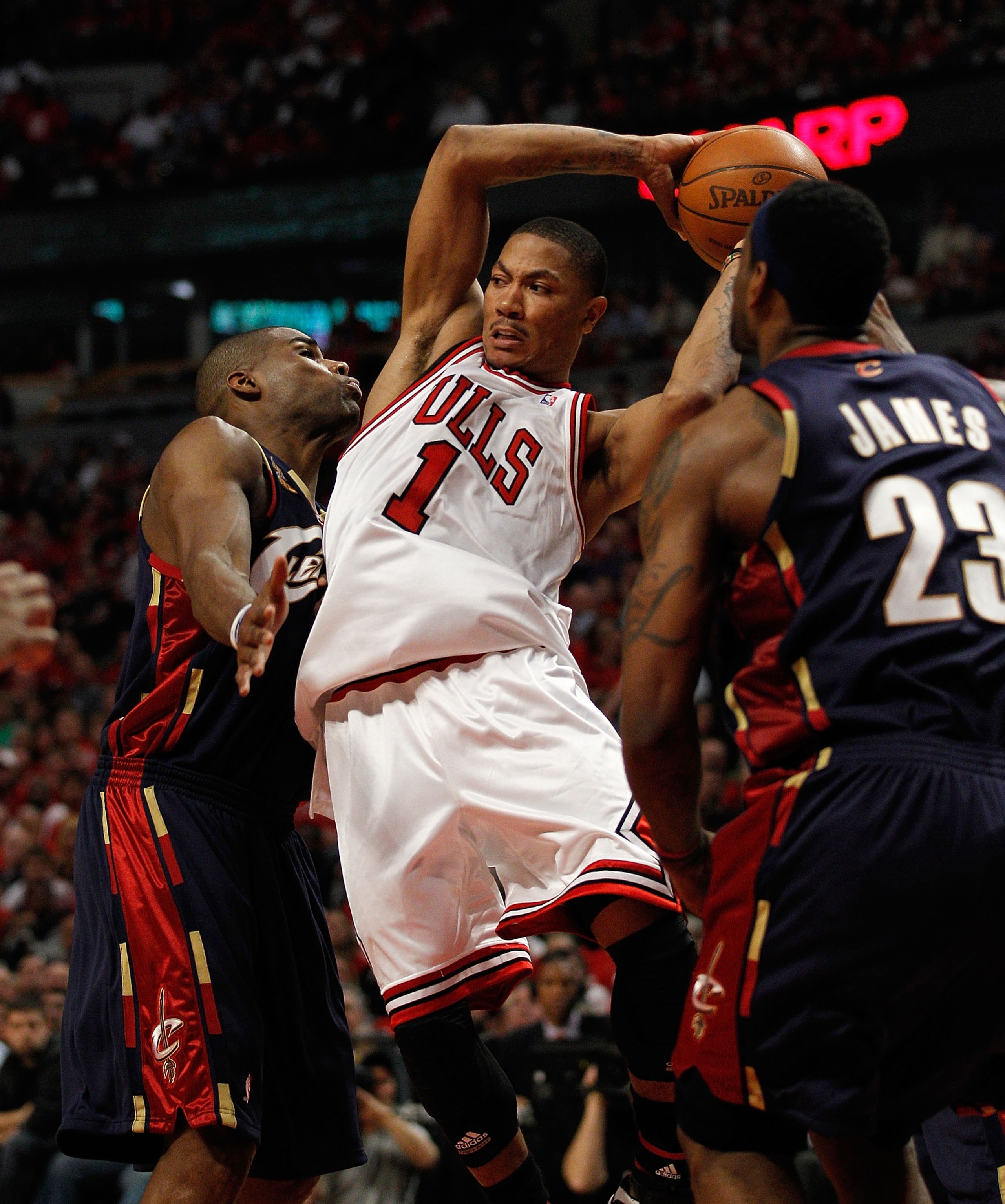 CHICAGO - APRIL 22: Derrick Rose #1 of the Chicago Bulls passes the ball between Antawn Jamison #4 and LeBron James #23 of the Cleveland Cavaliers in Game Three of the Eastern Conference Quarterfinals during the 2010 NBA Playoffs at the United Center on A