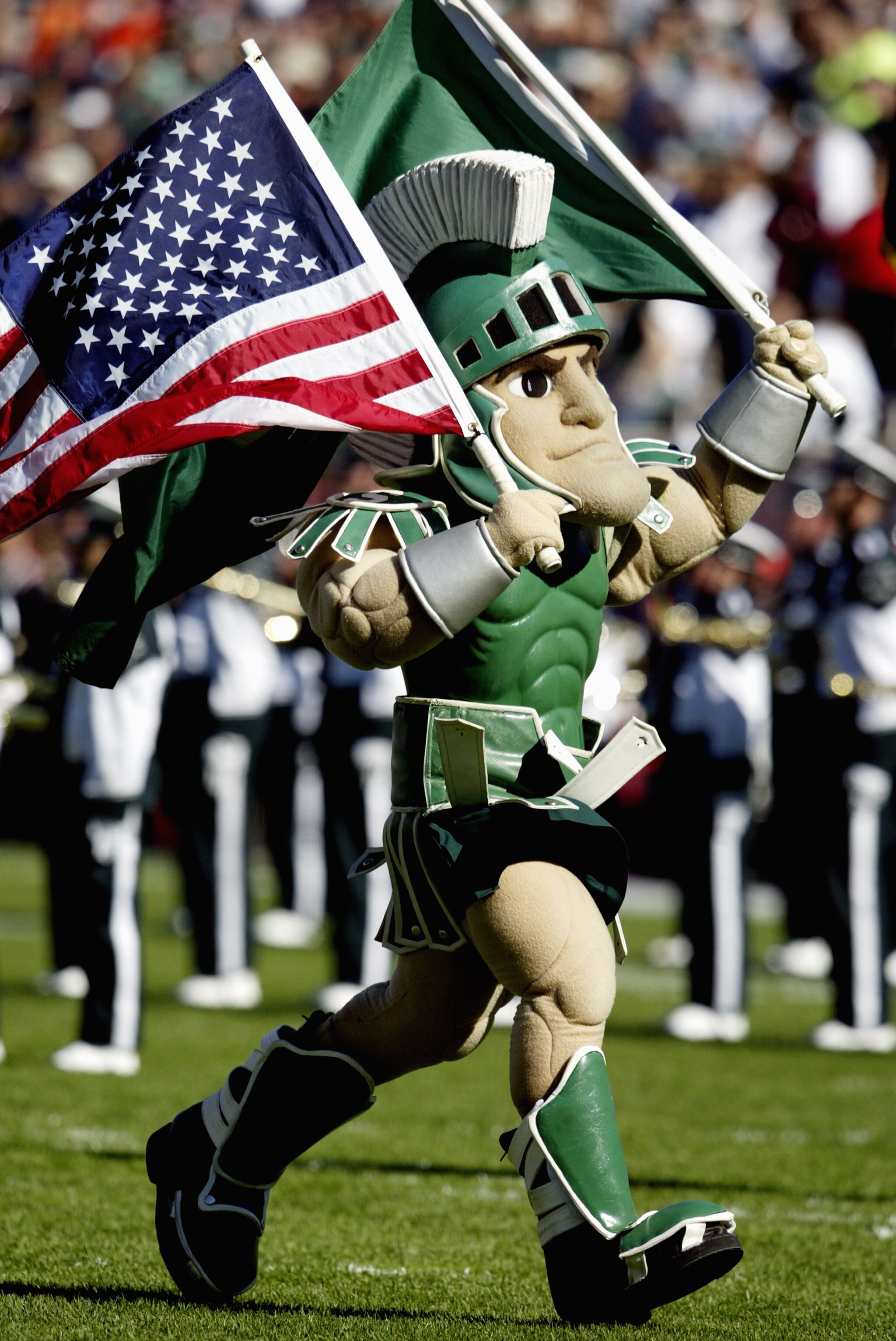 EAST LANSING, MI - OCTOBER 9:  Sparty, the Michigan State University Spartans mascot, carries the American Flag during the game against the University of Illinois Fighting Illini at Spartan Stadium on October 9, 2004 in East Lansing, Michigan. Michigan St