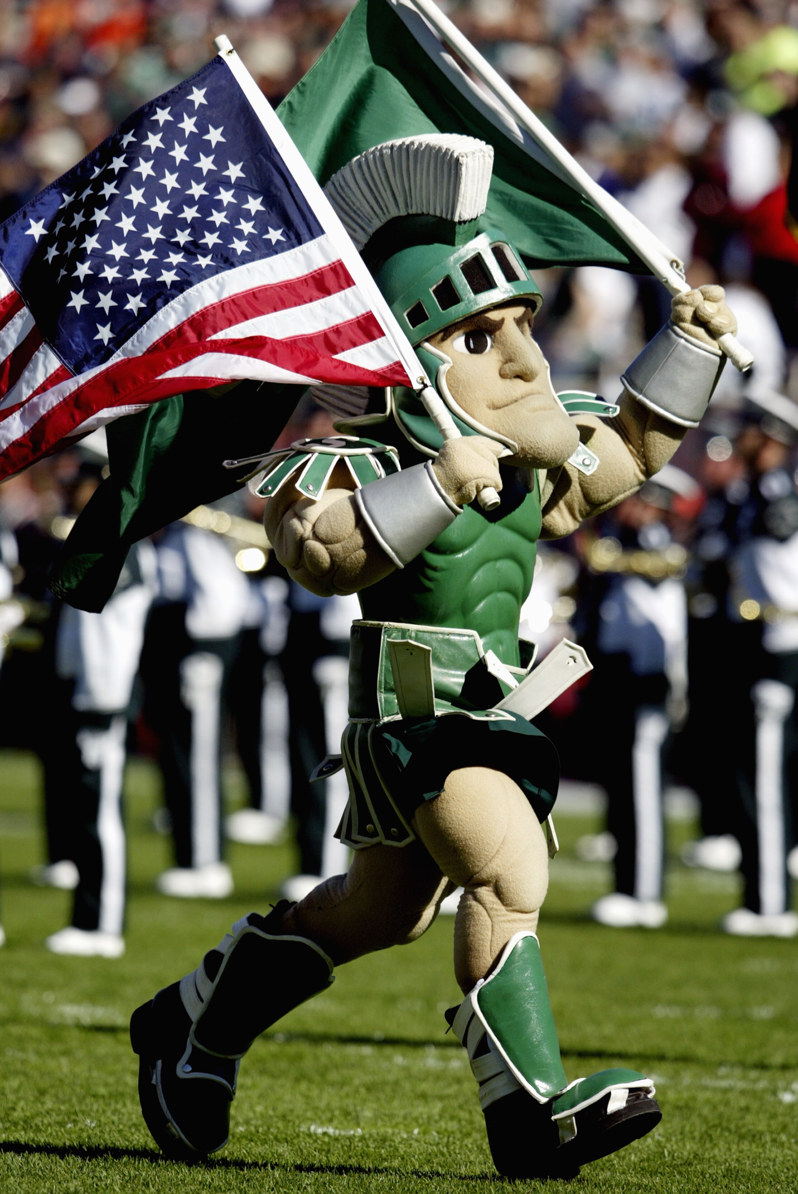 EAST LANSING, MI - OCTOBER 9:  Sparty, the Michigan State University Spartans mascot, carries the American Flag during the game against the University of Illinois Fighting Illini at Spartan Stadium on October 9, 2004 in East Lansing, Michigan. Michigan St