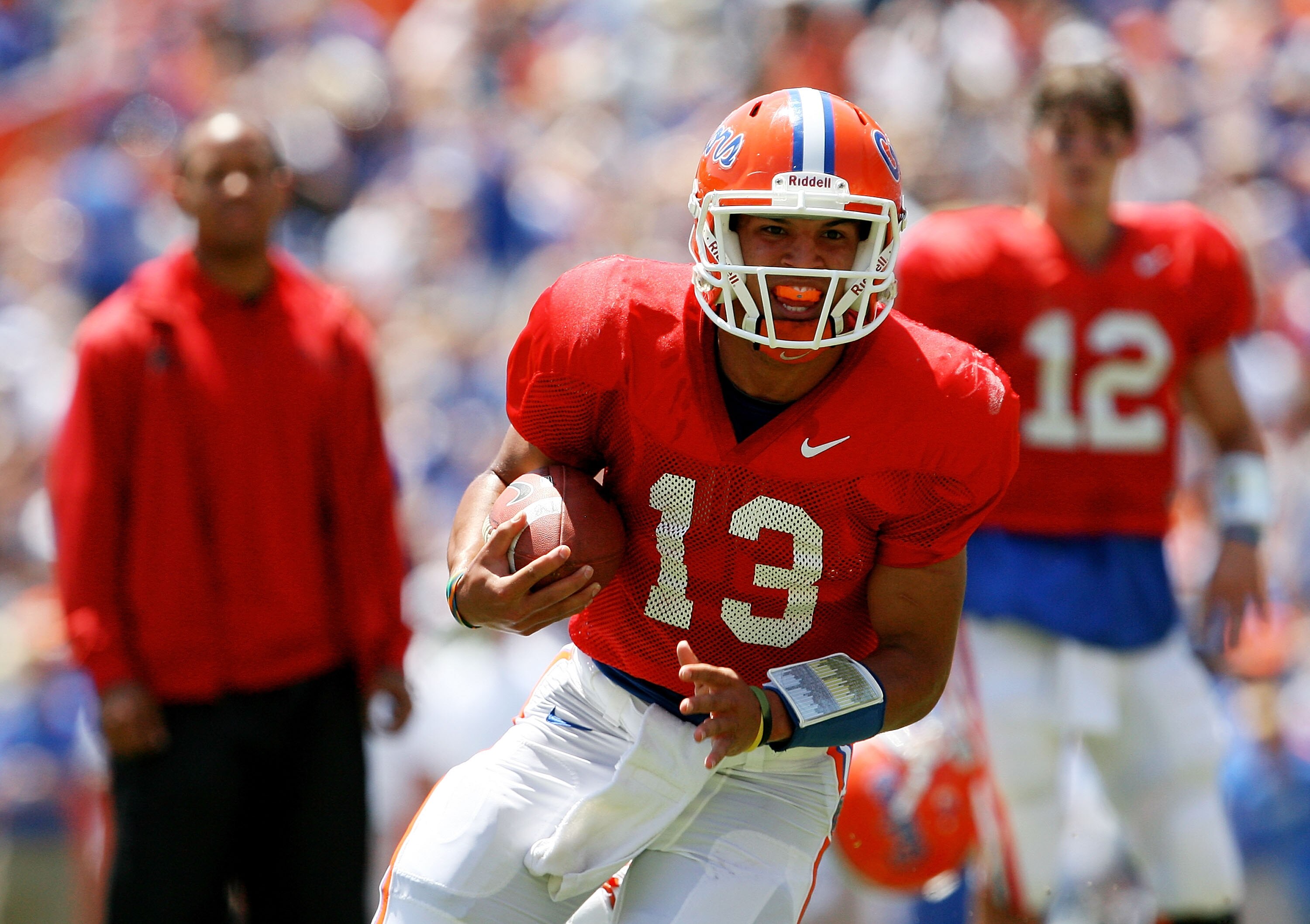 GAINESVILLE, FL - APRIL 10:  Quarterback Trey Burton #13 of the Florida Gators runs for a touchdown as former Gator Chris Leak, L, and quarterback John Brantley #12 look on during the Orange & Blue game at Ben Hill Griffin Stadium on April 10, 2010 in Gai