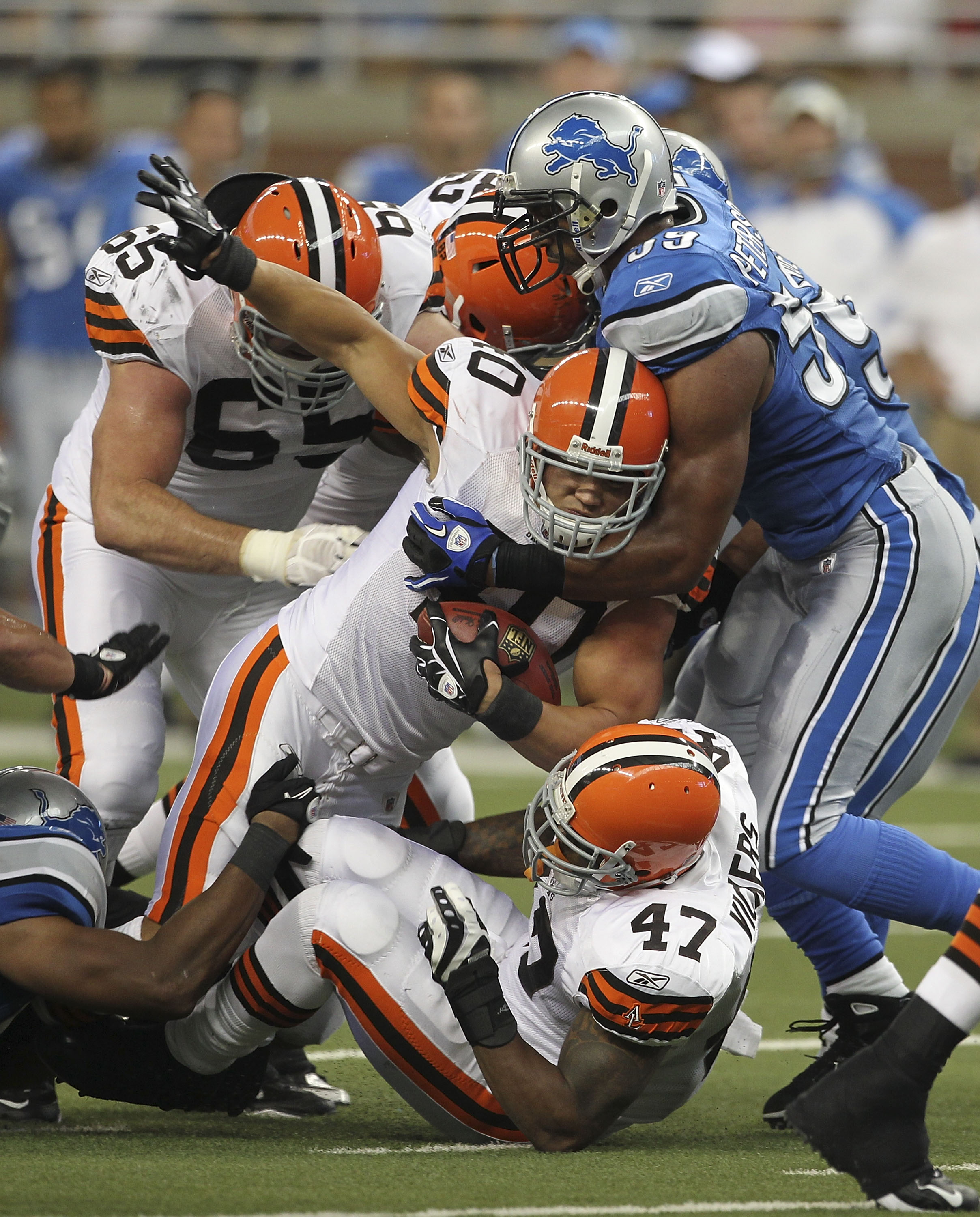 DETROIT - AUGUST 28: Peyton Hillis #40 of the Cleveland Browns rushes for a short gain as Julian Peterson #59 of the Detroit Lions makes the stop during the preseason game at Ford Field on August 28, 2010 in Detroit, Michigan. (Photo by Leon Halip/Getty I
