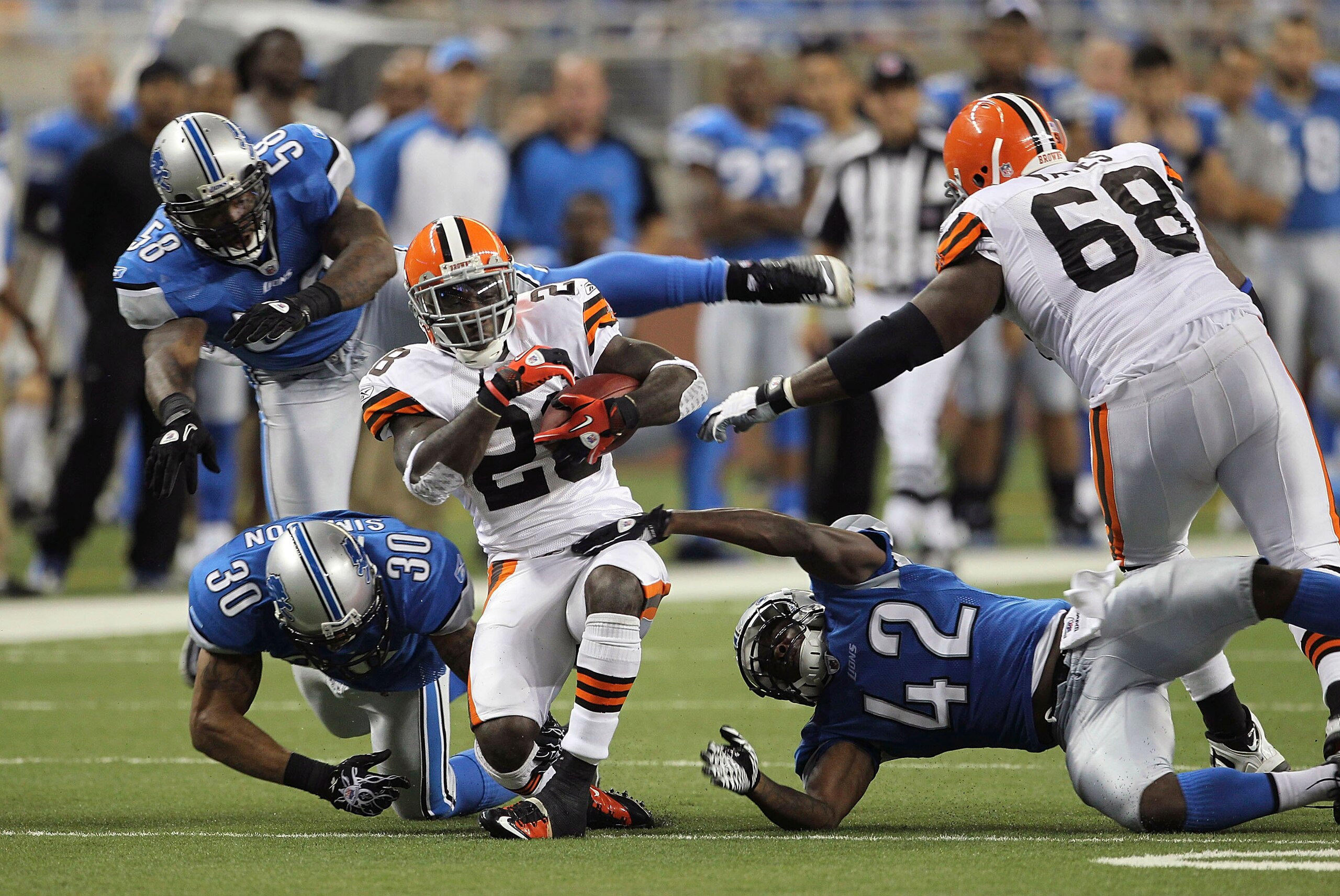 DETROIT - AUGUST 28: James Davis #28 of the Cleveland Browns runs for a short gain as Ko Simpson #30 and Amari Spievey #42 make the stop during the third quarter of the preseason game against the Detroit Lions at Ford Field on August 28, 2010 in Detroit, 
