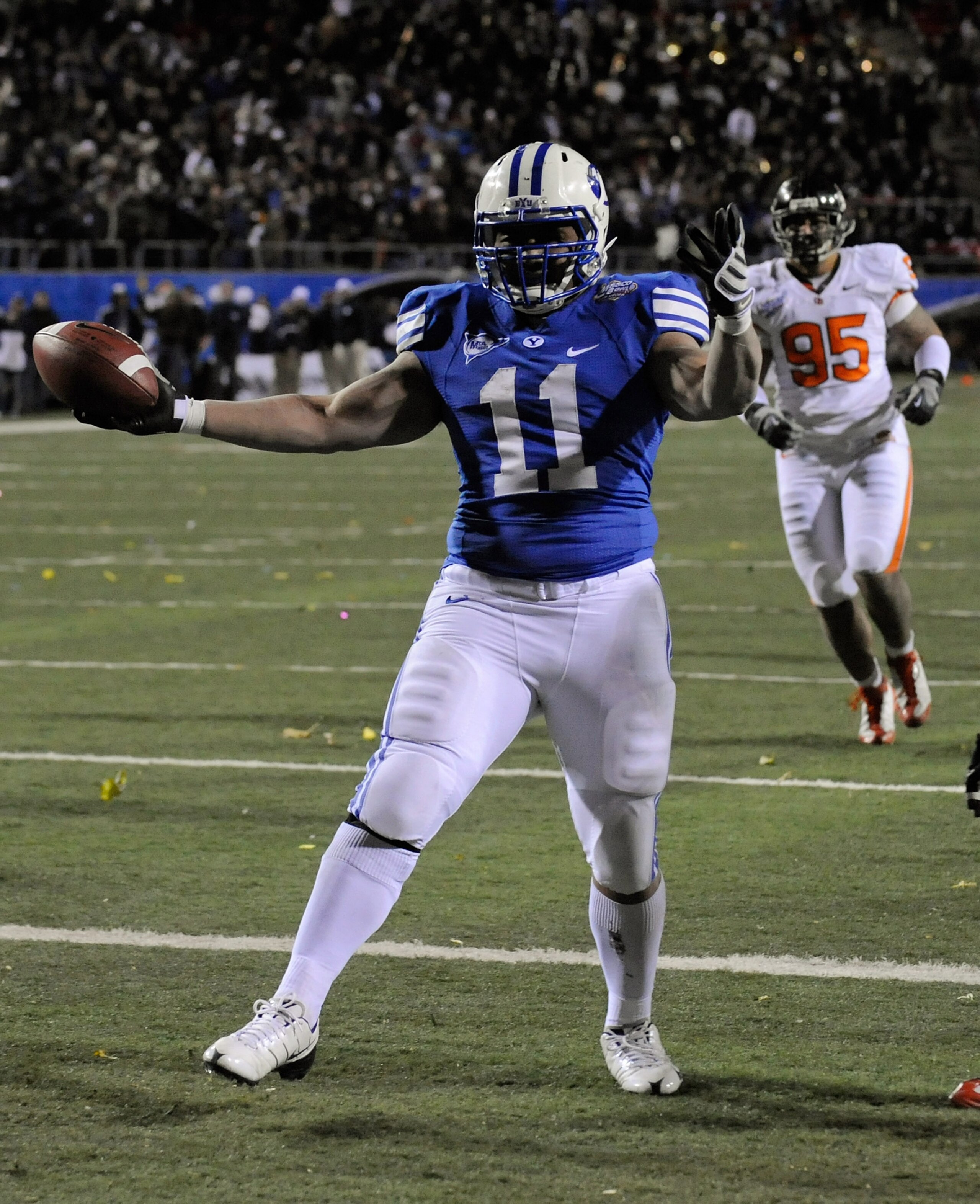 LAS VEGAS - DECEMBER 22:  Manase Tonga #11 of the Brigham Young University Cougars celebrates as he scores a touchdown in front of Latu Moala #95 of the Oregon State Beavers in the fourth quarter of the MAACO Las Vegas Bowl at Sam Boyd Stadium December 22