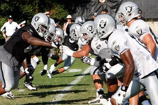 Raiders players at the snap of the ball in practice.