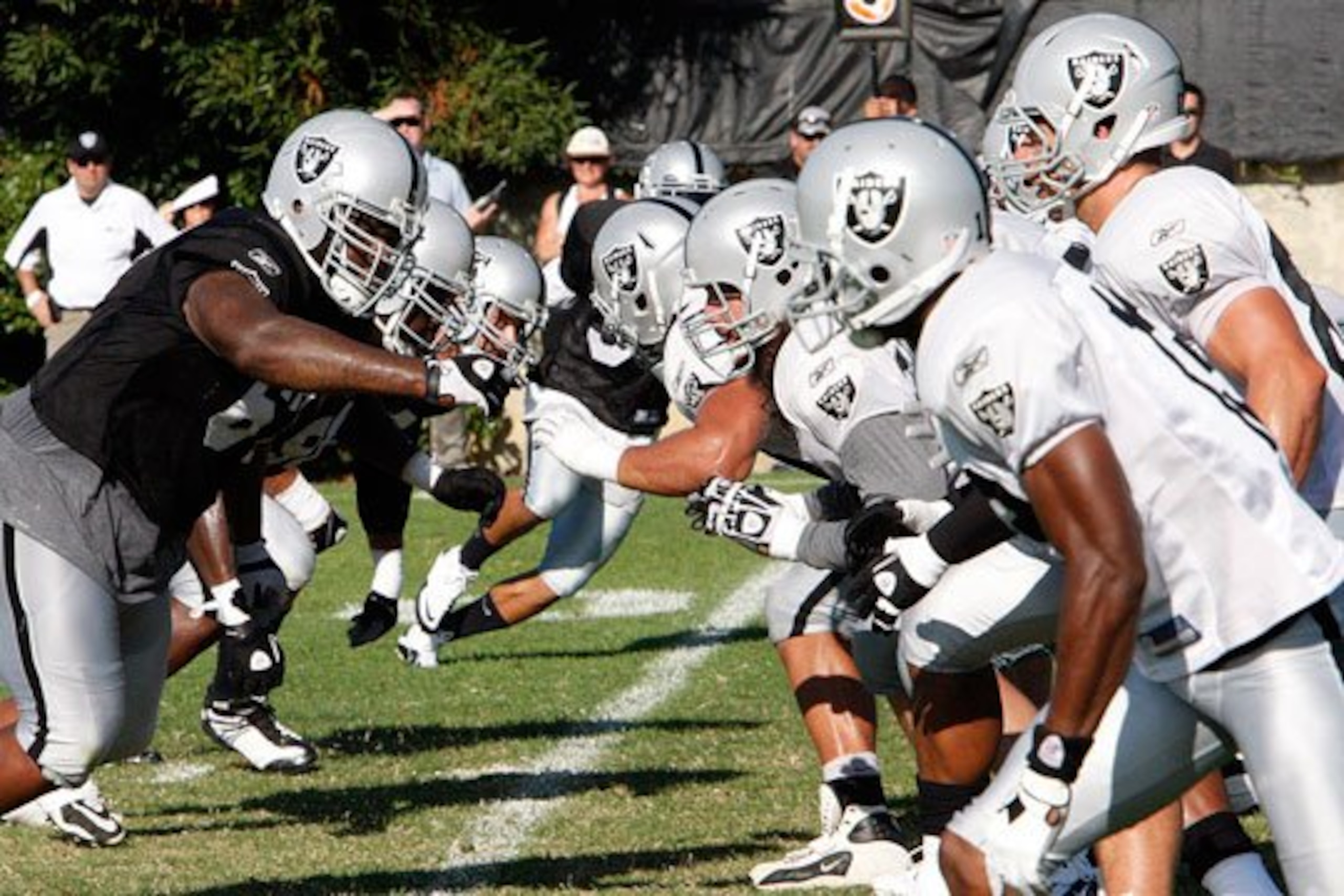 Raiders players at the snap of the ball in practice.