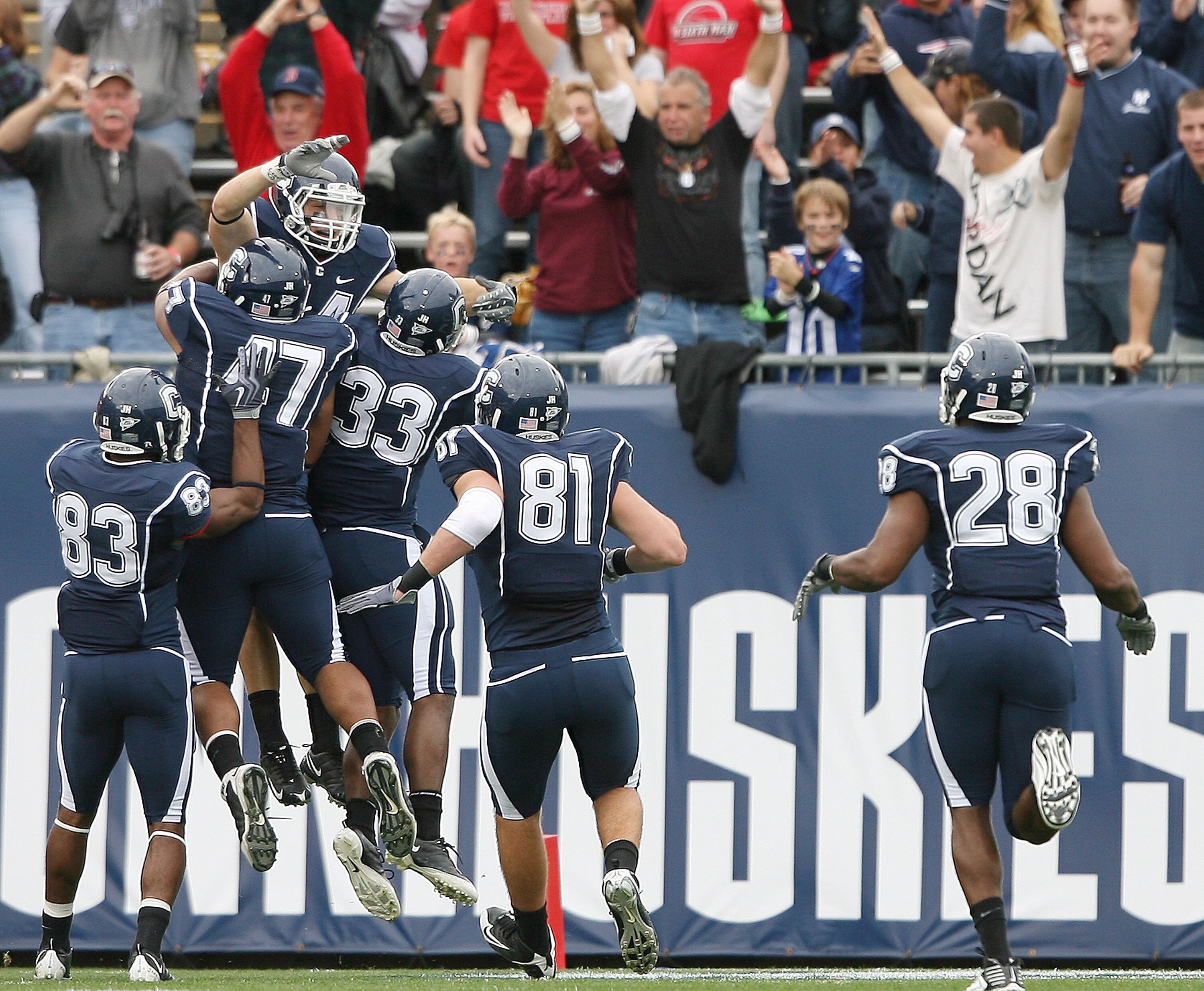 EAST HARTFORD, CT - OCTOBER 31:  Robbie Frey #44 of the Connecticut Huskies is congratulated by teammates Corey Manning #81,Robert Vaughn #33, Anthony Davis #47 and Isiah Moore #83 after Frey returned a kickoff 100 yards for a touchdown in the second quar