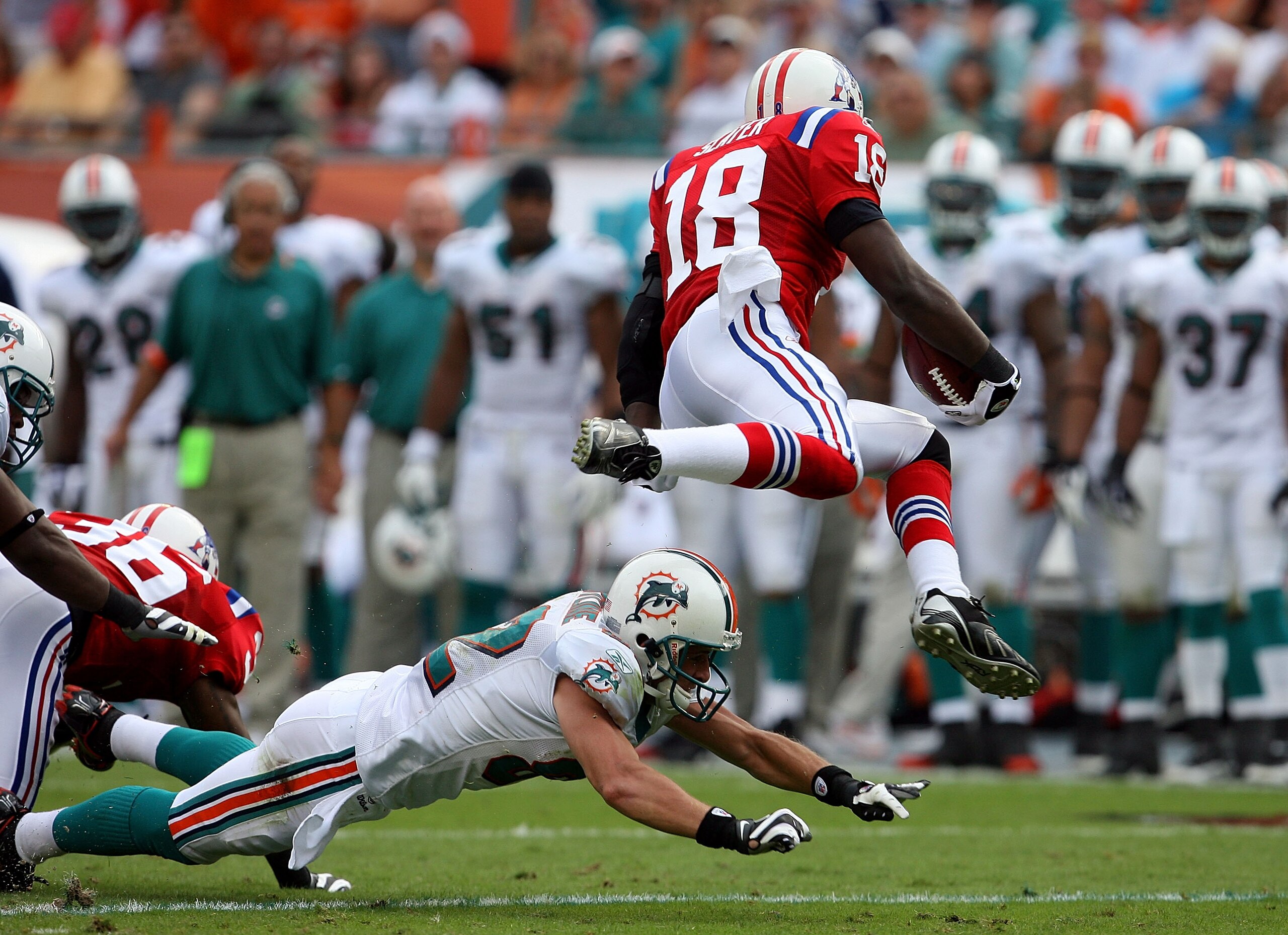 MIAMI - DECEMBER 06:  Wide receiver Matthew Slater #18 of the New England Patriots gets taken down by wide receiveer Brain Hartline #82 of the Miami Dolphins at Land Shark Stadium on December 6, 2009 in Miami, Florida. The Dolphins defeated the Patriots 2