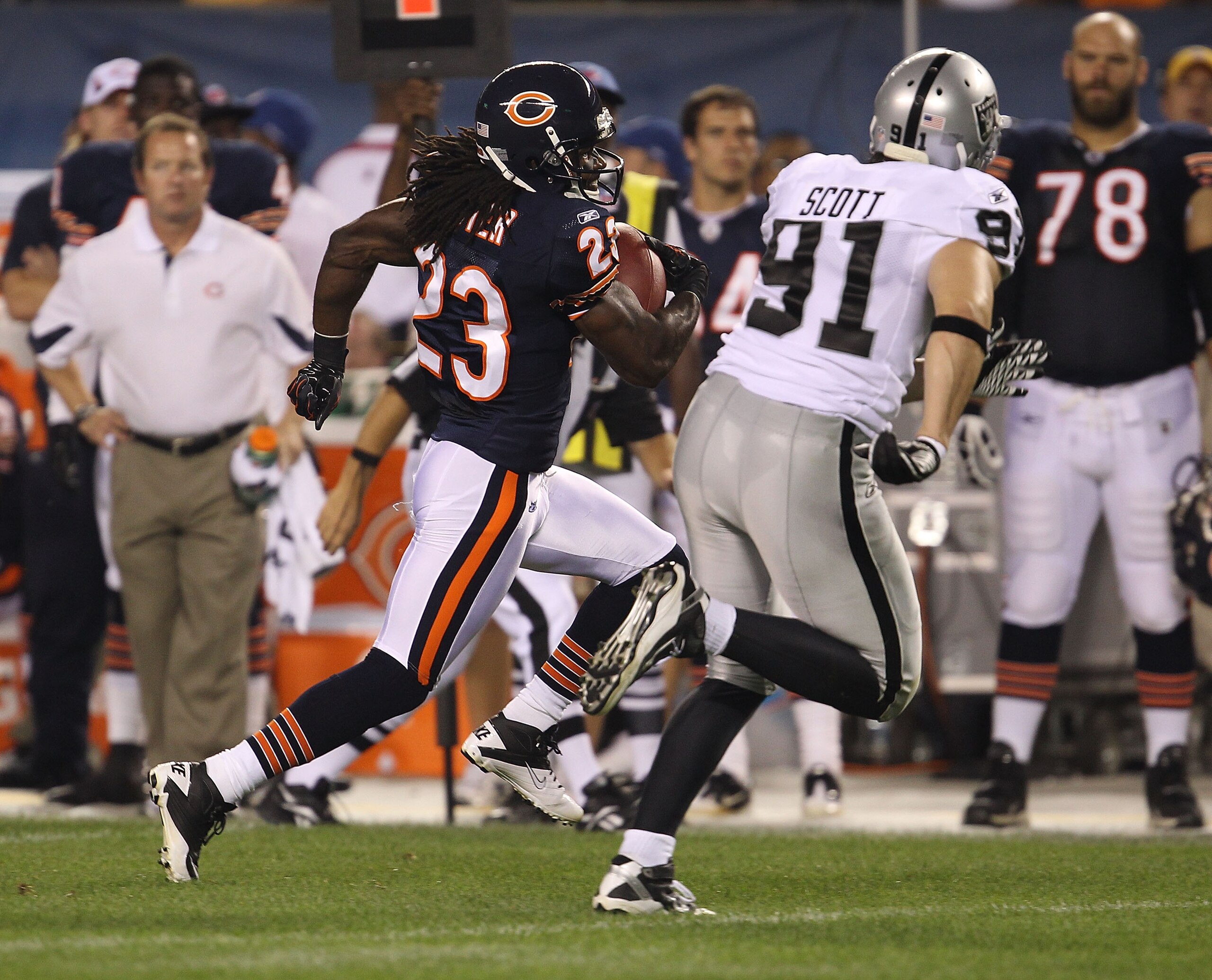 CHICAGO - AUGUST 21: Devin Hester #23 of the Chicago Bears runs after catching a pass as Trevor Scott #91 of the Oakland Raiders pursues during a preseason game at Soldier Field on August 21, 2010 in Chicago, Illinois. The Raiders defeated the Bears 32-17