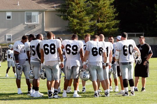 Offensive linemen get instructions for a day of practice.