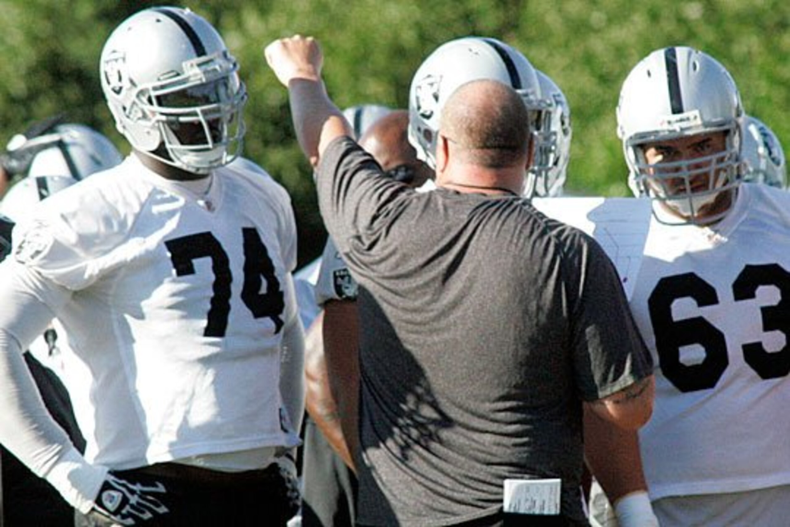 Bruce Campbell and Brandon Rodd get coached up by Tom Cable.
