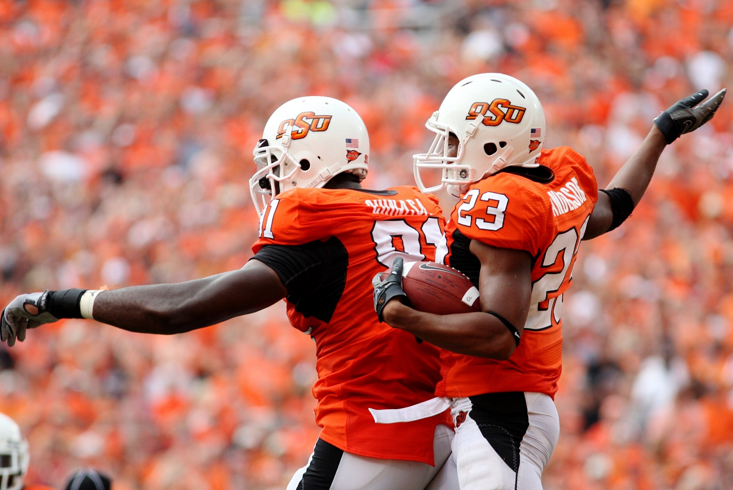 STILLWATER, OK - SEPTEMBER 5:  Ugo Chinasa #91 and Terrance Anderson #23 of the Oklahoma State Cowboys defense celebrate recovering a fumble  in the second quarter of the game against the Georgia Bulldogs at Boone Pickens Stadium on September 5, 2009 in S