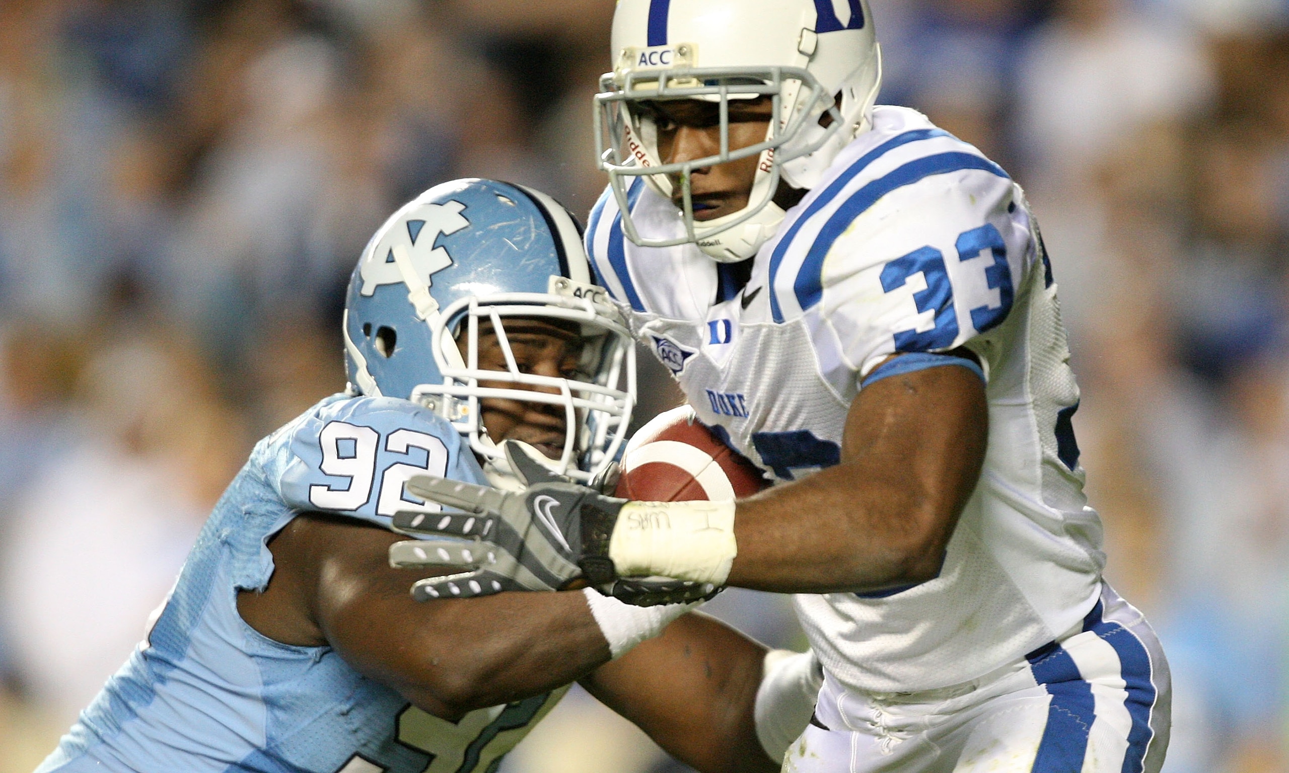 CHAPEL HILL, NC - NOVEMBER 07:  Desmond Scott #33 of the Duke Blue Devils is tackled by E.J. Wilson #92 of the North Carolina Tar Heels during their game at Kenan Stadium on November 7, 2009 in Chapel Hill, North Carolina.  (Photo by Streeter Lecka/Getty