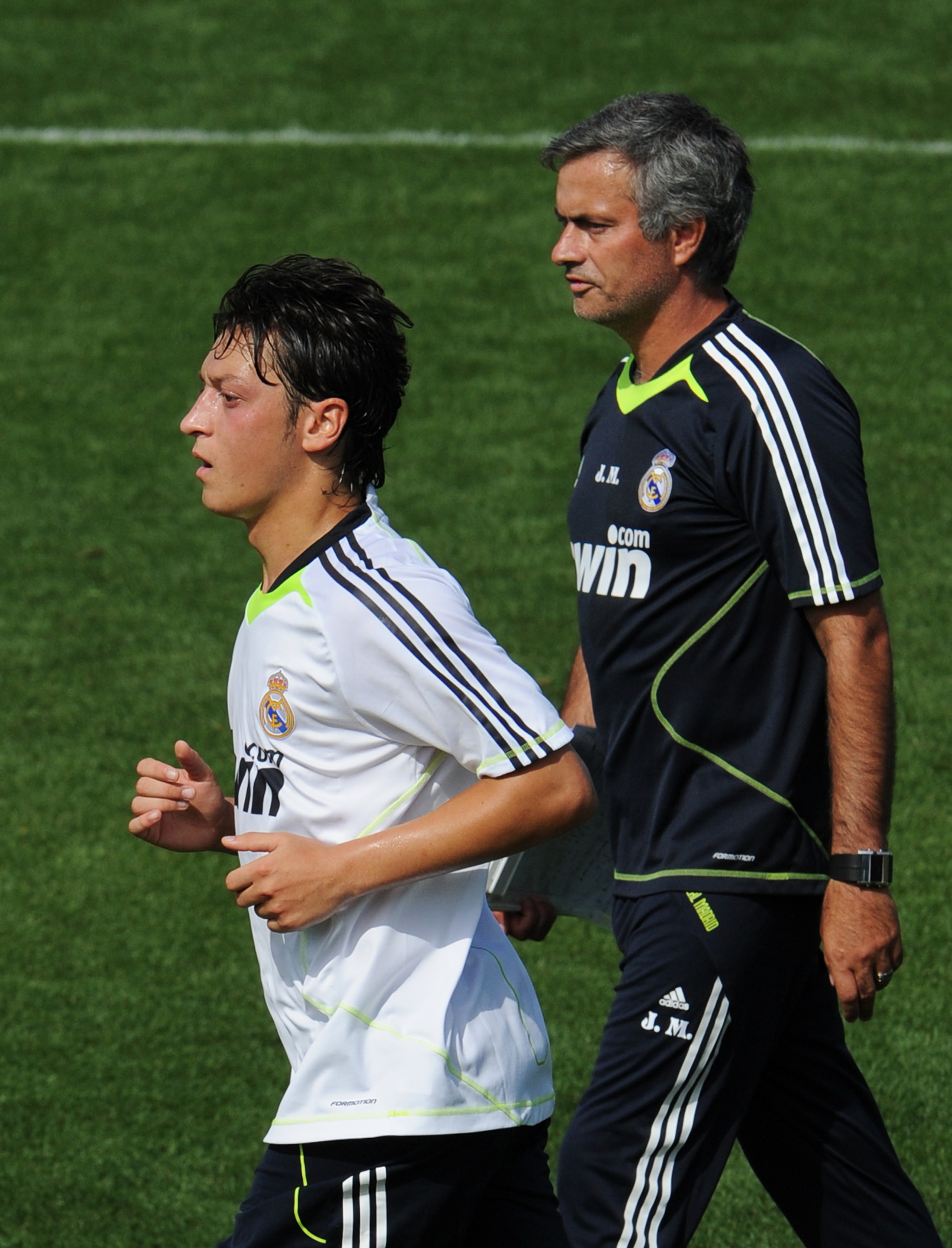 MADRID, SPAIN - AUGUST 19:  New signing Mesut Ozil (L) of Real Madrid runs past his coach Jose Mourinho during a training session at the Valdebebas training ground on August 19, 2010 in Madrid, Spain.  (Photo by Jasper Juinen/Getty Images)