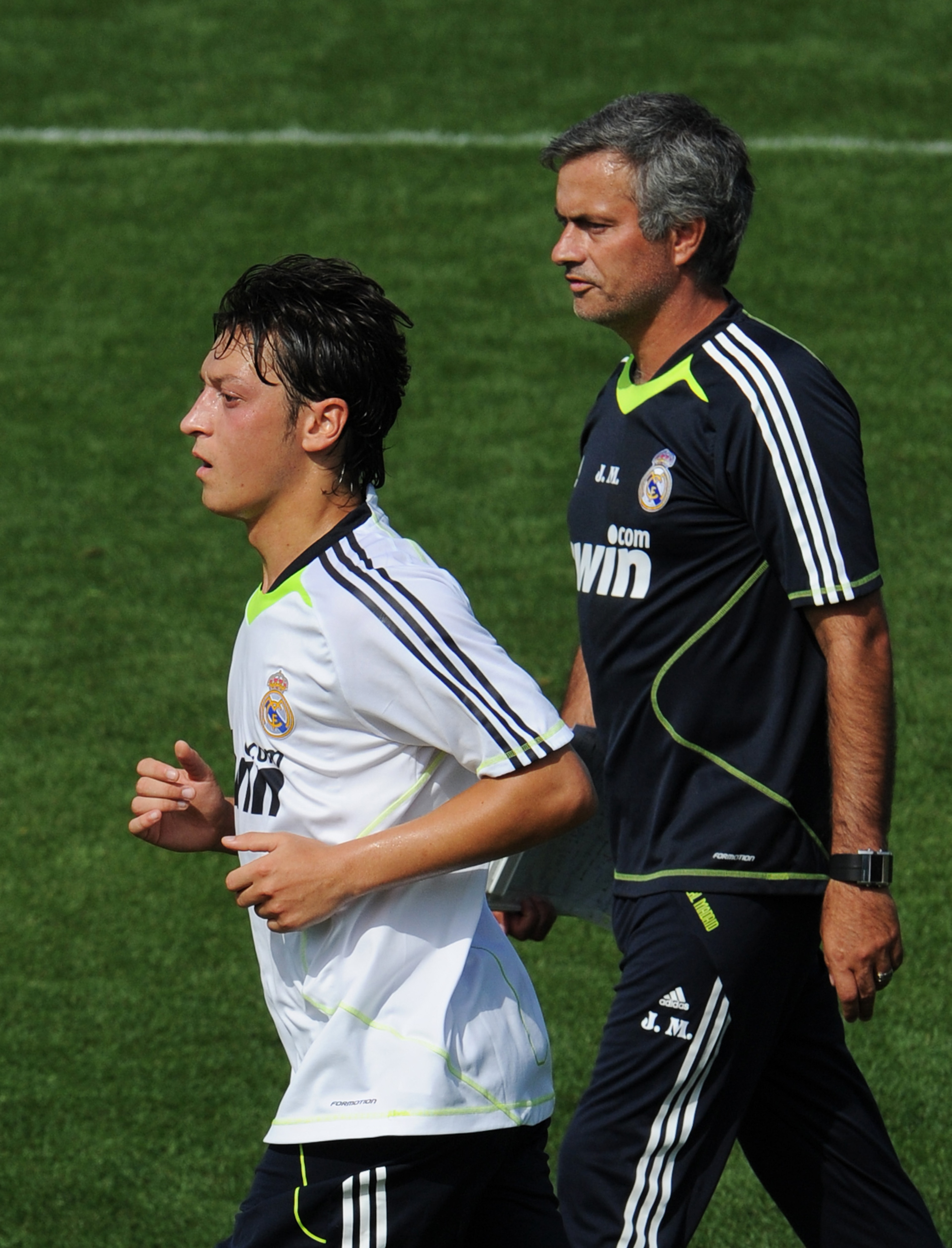 MADRID, SPAIN - AUGUST 19:  New signing Mesut Ozil (L) of Real Madrid runs past his coach Jose Mourinho during a training session at the Valdebebas training ground on August 19, 2010 in Madrid, Spain.  (Photo by Jasper Juinen/Getty Images)