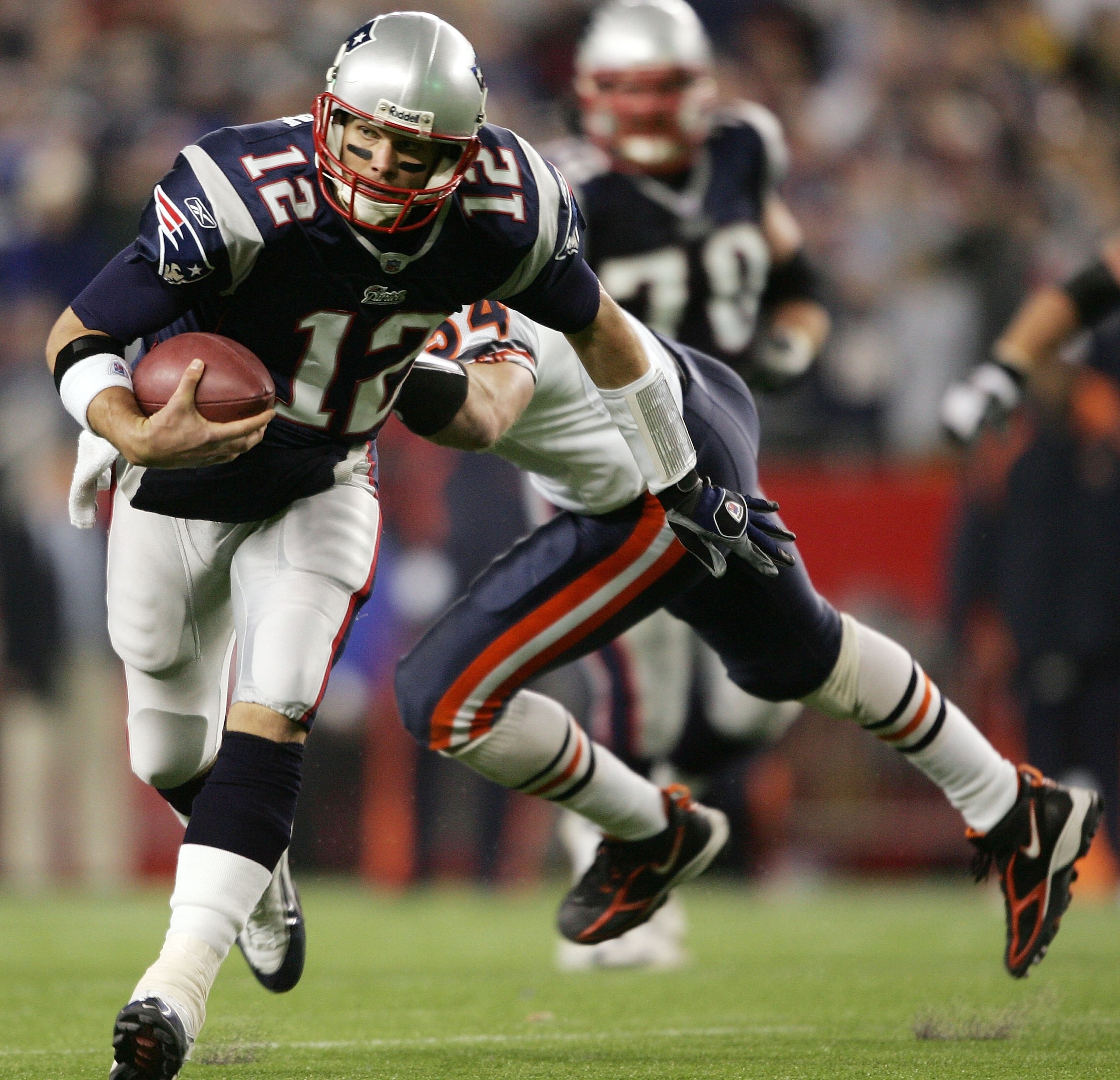 FOXBORO, MA - NOVEMBER 26:  Tom Brady #12 of the New England Patriots slips past Brian Urlacher #54 of the Chicago Bears to get the first down on November 26, 2006 at Gillette Stadium in Foxboro, Massachusetts. The New England Patriots defeated the Chicag