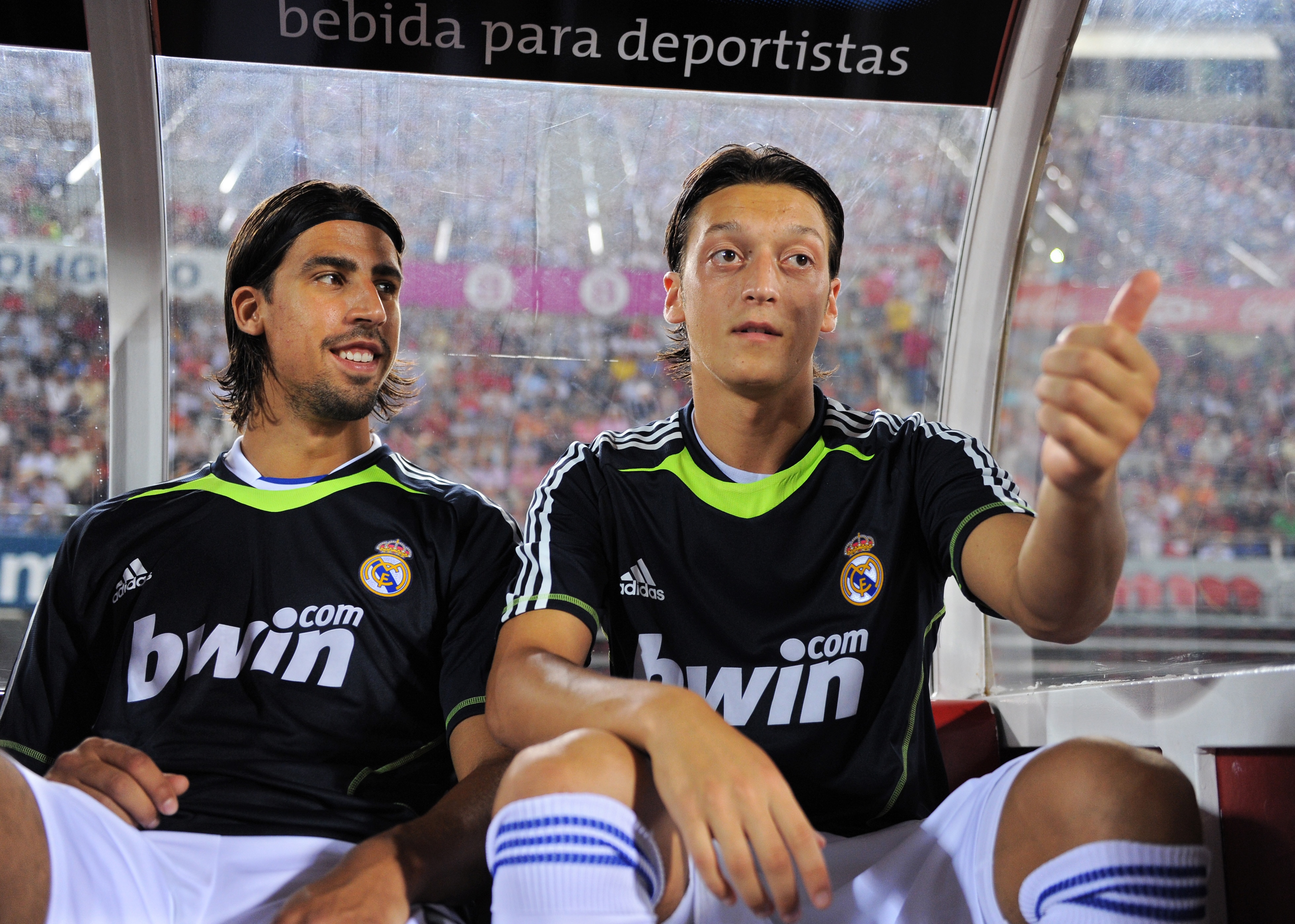PALMA DE MALLORCA, SPAIN - AUGUST 29: Mesut Ozil (R) of Real Madrid jokes while seated on the bench flanked by his teammate and fellow countryman Sami Khedira during the La Liga match between Mallorca and Real Madrid at the ONO Estadio on August 29, 2010 PALMA DE MALLORCA, SPAIN - AUGUST 29: Mesut Ozil (R) of Real Madrid jokes while seated on the bench flanked by his teammate and fellow countryman Sami Khedira during the La Liga match between Mallorca and Real Madrid at the ONO Estadio on August 29, 2010