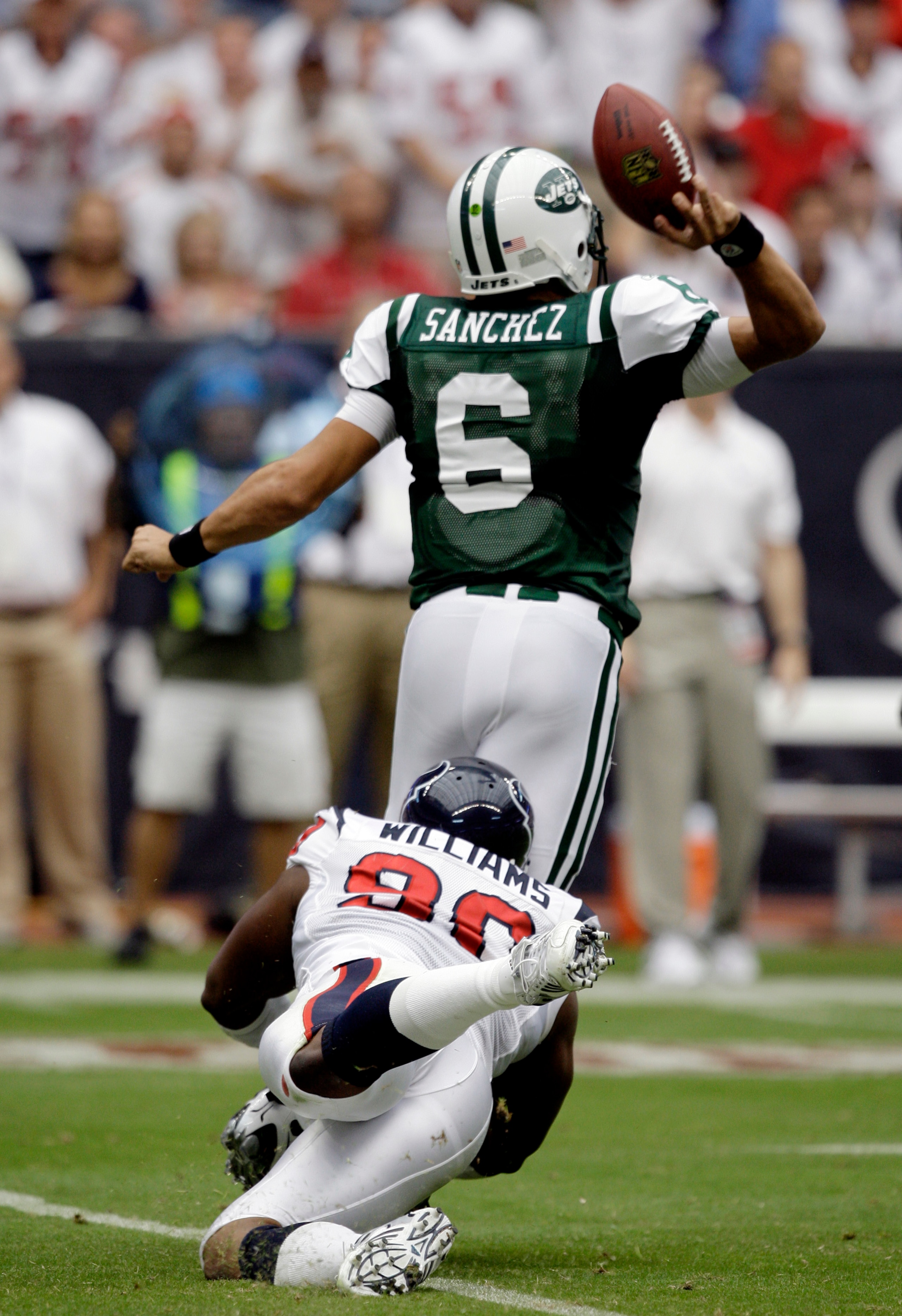 HOUSTON - SEPTEMBER 13: Quarterback Mark Sanchez #6 of the New York Jets is tackled from behind by defensive end Mario Williams #90 of the Houston Texans as he releases the ball at Reliant Stadium on September 13, 2009 in Houston, Texas.  (Photo by Bob Le