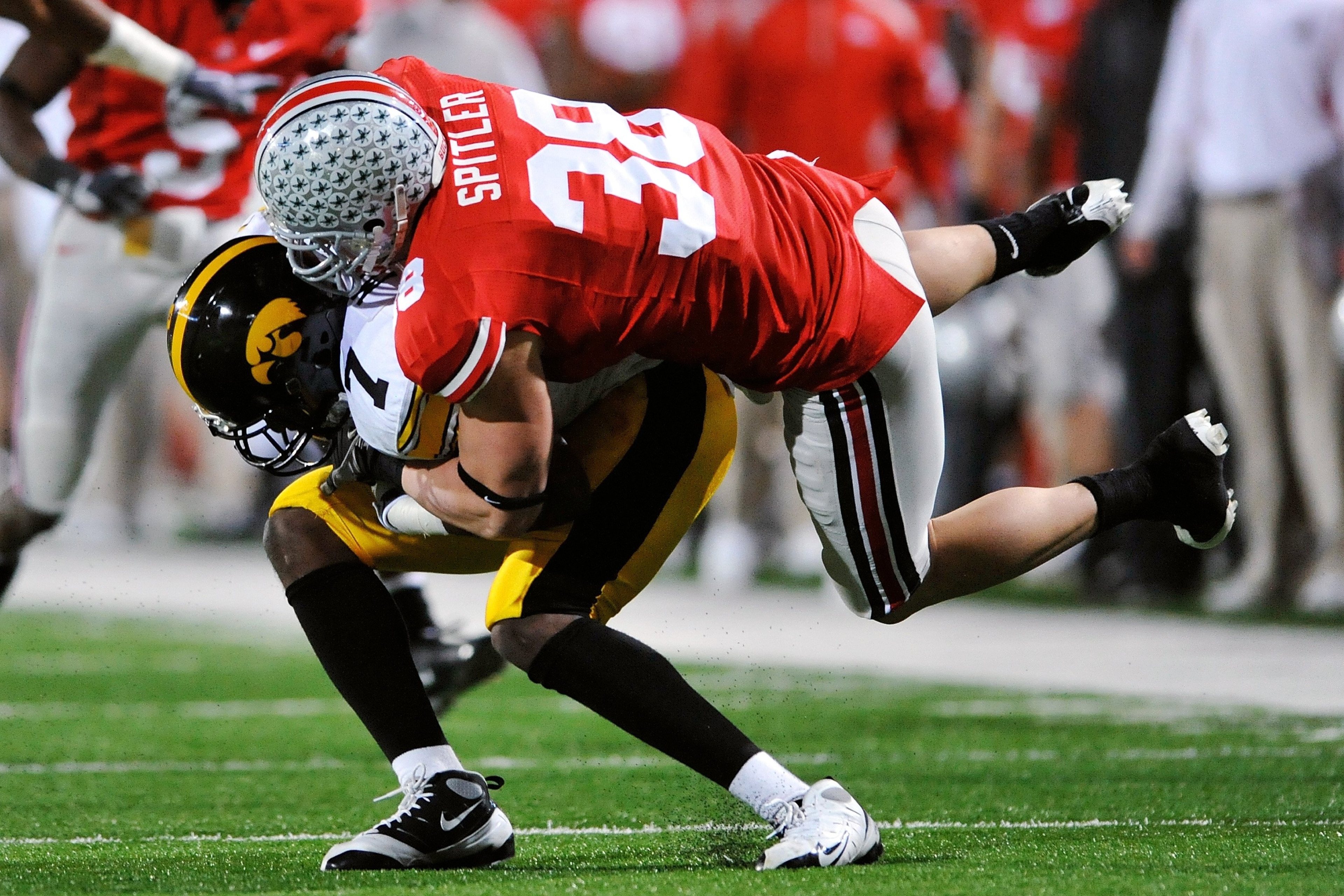 COLUMBUS, OH - NOVEMBER 14:  Linebacker Austin Spitler #38 of the Ohio State Buckeyes tackles wide receiver Marvin McNutt #7 of the Iowa Hawkeyes at Ohio Stadium on November 14, 2009 in Columbus, Ohio.  (Photo by Jamie Sabau/Getty Images)