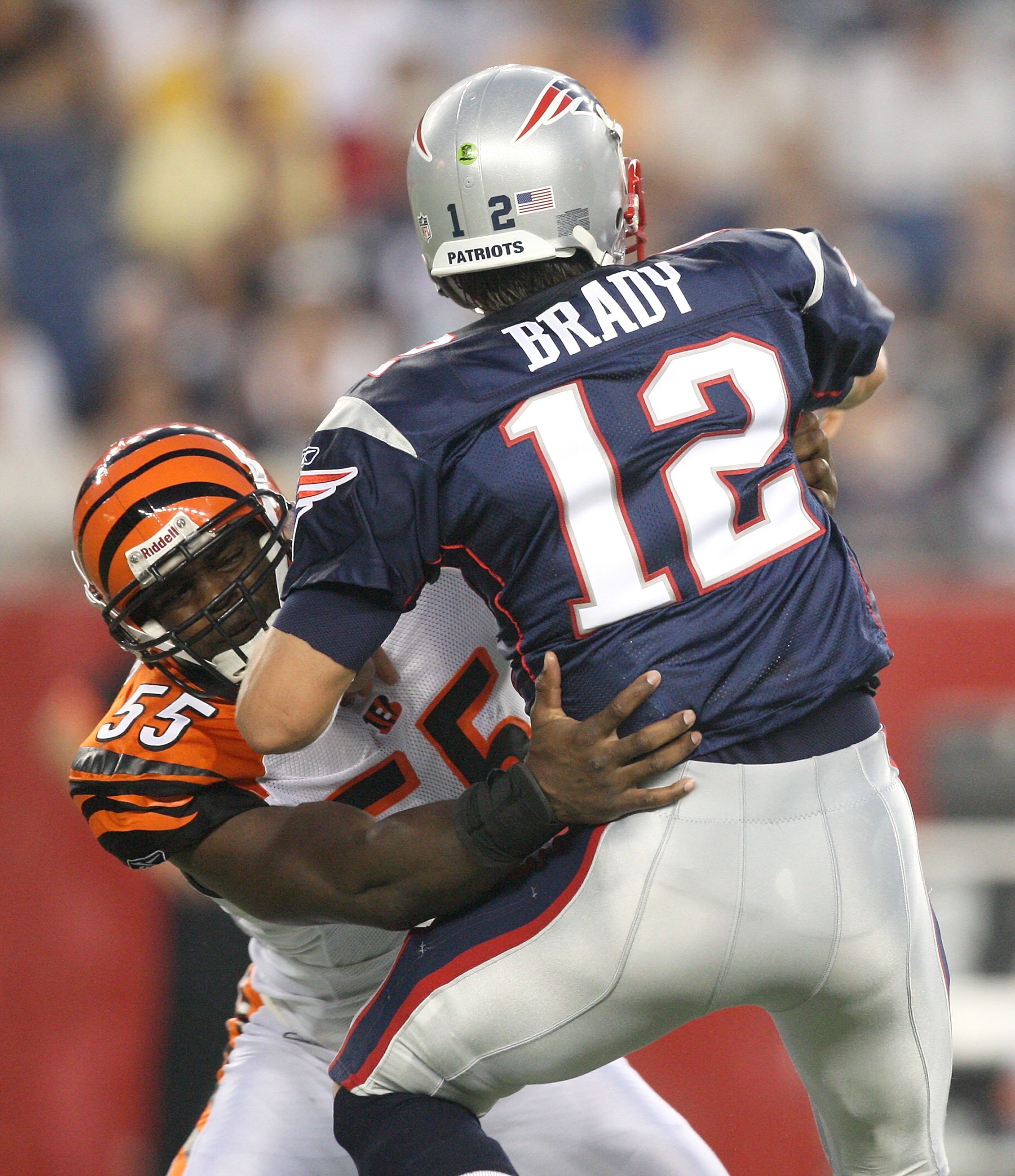 FOXBORO, MA - AUGUST 20:  Tom Brady #12 of the New England Patriots feels the pressure of Keith Rivers #55 of the Cincinnati Bengals at Gillette Stadium on August 20, 2009 in Foxboro, Massachusetts. (Photo by Jim Rogash/Getty Images)