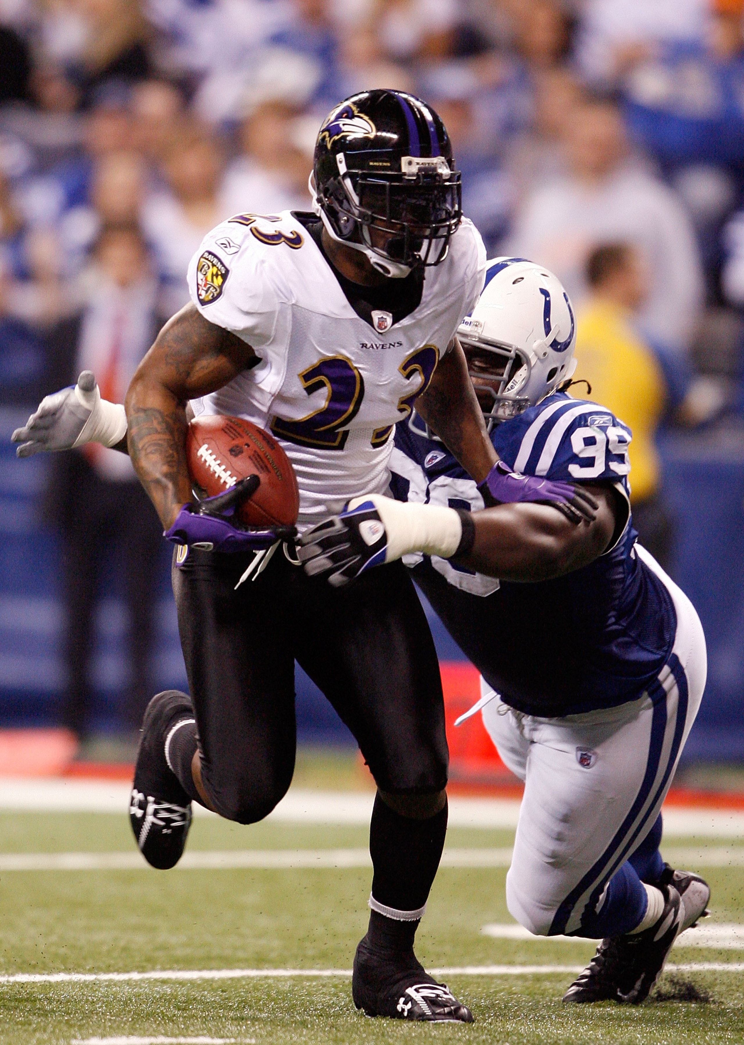 INDIANAPOLIS - JANUARY 16:  Willis McGahee #23 of the Baltimore Ravens runs the ball as Antonio Johnson #99 of the Indianapolis Colts looks to tackle him from behind in the first quarter of the AFC Divisional Playoff Game at Lucas Oli Stadium on January 1