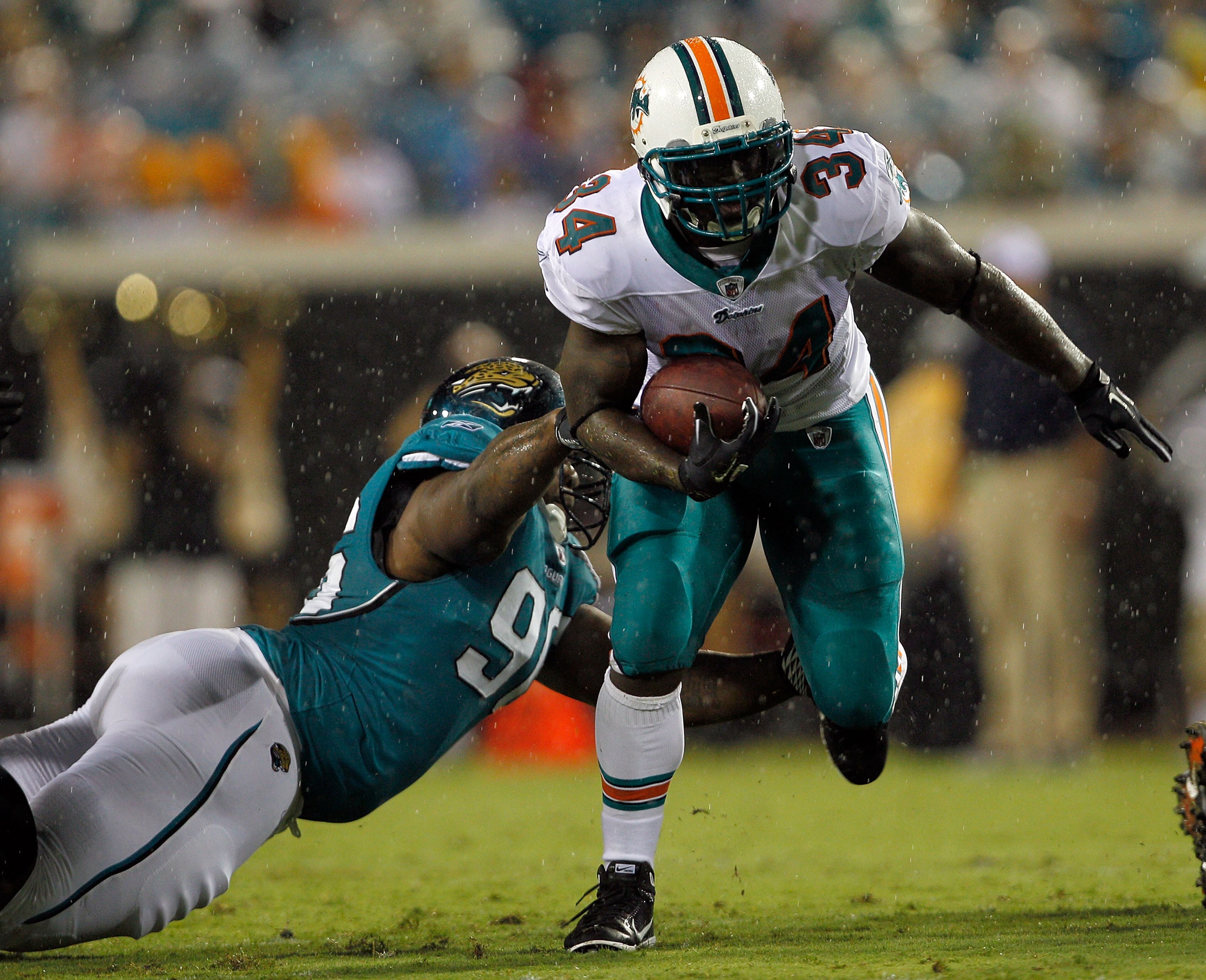 JACKSONVILLE, FL - AUGUST 21:  Terrance Knighton #96 of the Jacksonville Jaguars attempts to tackle Ricky Williams #34 of the Miami Dolphins during the preseason game at EverBank Field on August 21, 2010 in Jacksonville, Florida.  (Photo by Sam Greenwood/
