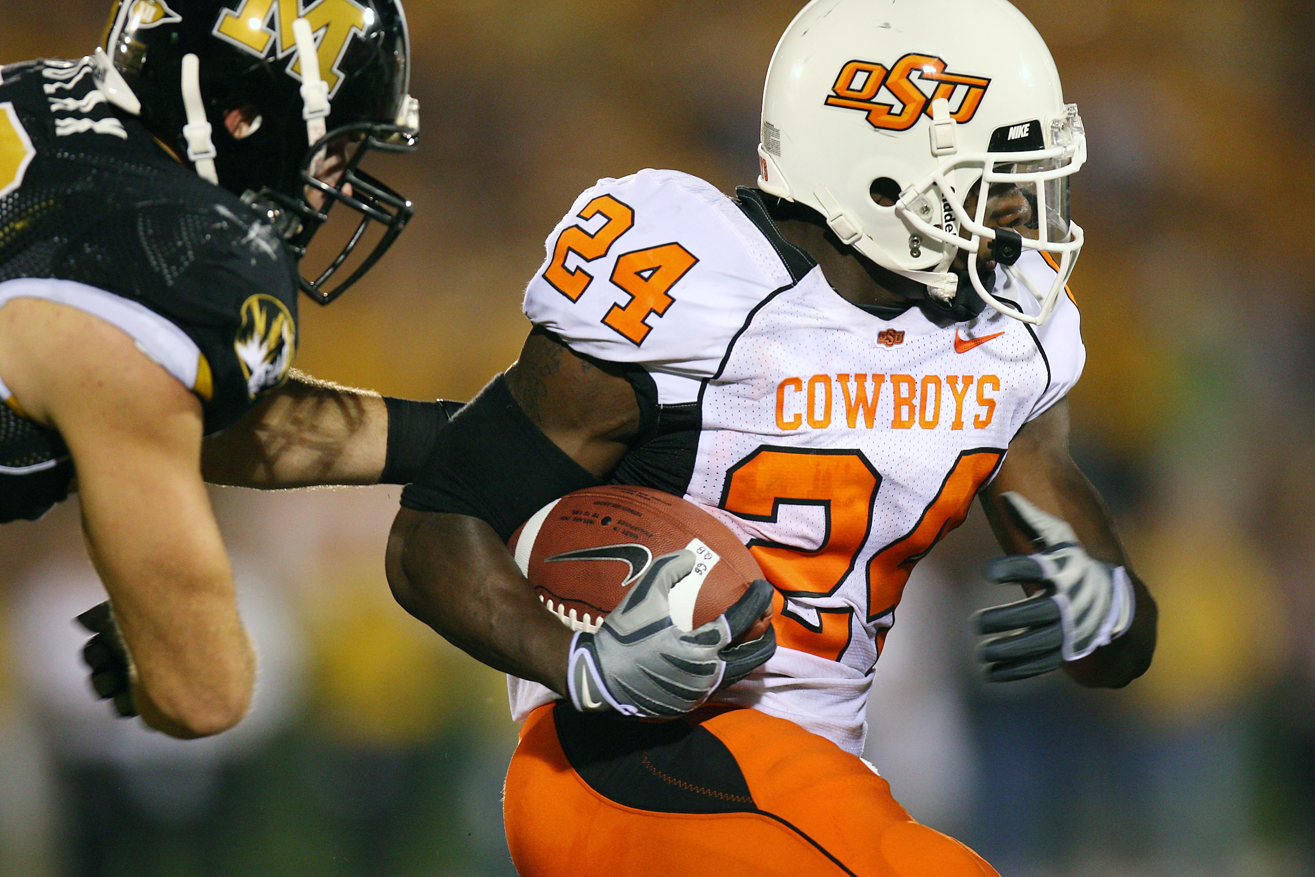 COLUMBIA, MO - OCTOBER 11:  Kendall Hunter #24 of the Oklahoma State Cowboys drags a defender of the Missouri Tigers for yardage on October 11, 2008 at Memorial Stadium in Columbia, Missouri.  (Photo by G. Newman Lowrance/Getty Images)