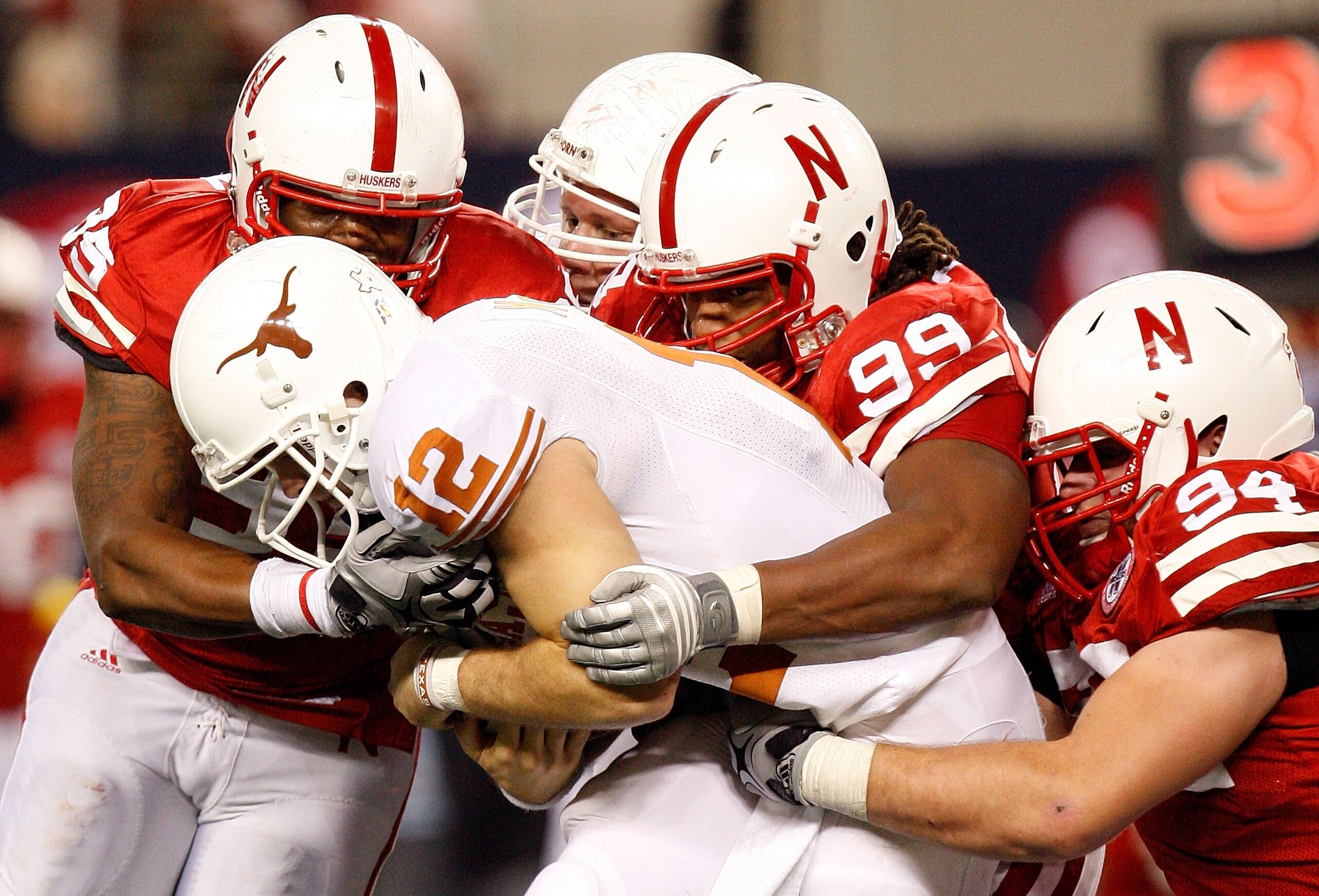 ARLINGTON, TX - DECEMBER 05:  Pierre Allen #95, Barry Turner #99 and Jared Crick #94 of the Nebraska Cornhuskers tackle Colt McCoy #12 of the Texas Longhorns at Cowboys Stadium on December 5, 2009 in Arlington, Texas.  (Photo by Ronald Martinez/Getty Imag