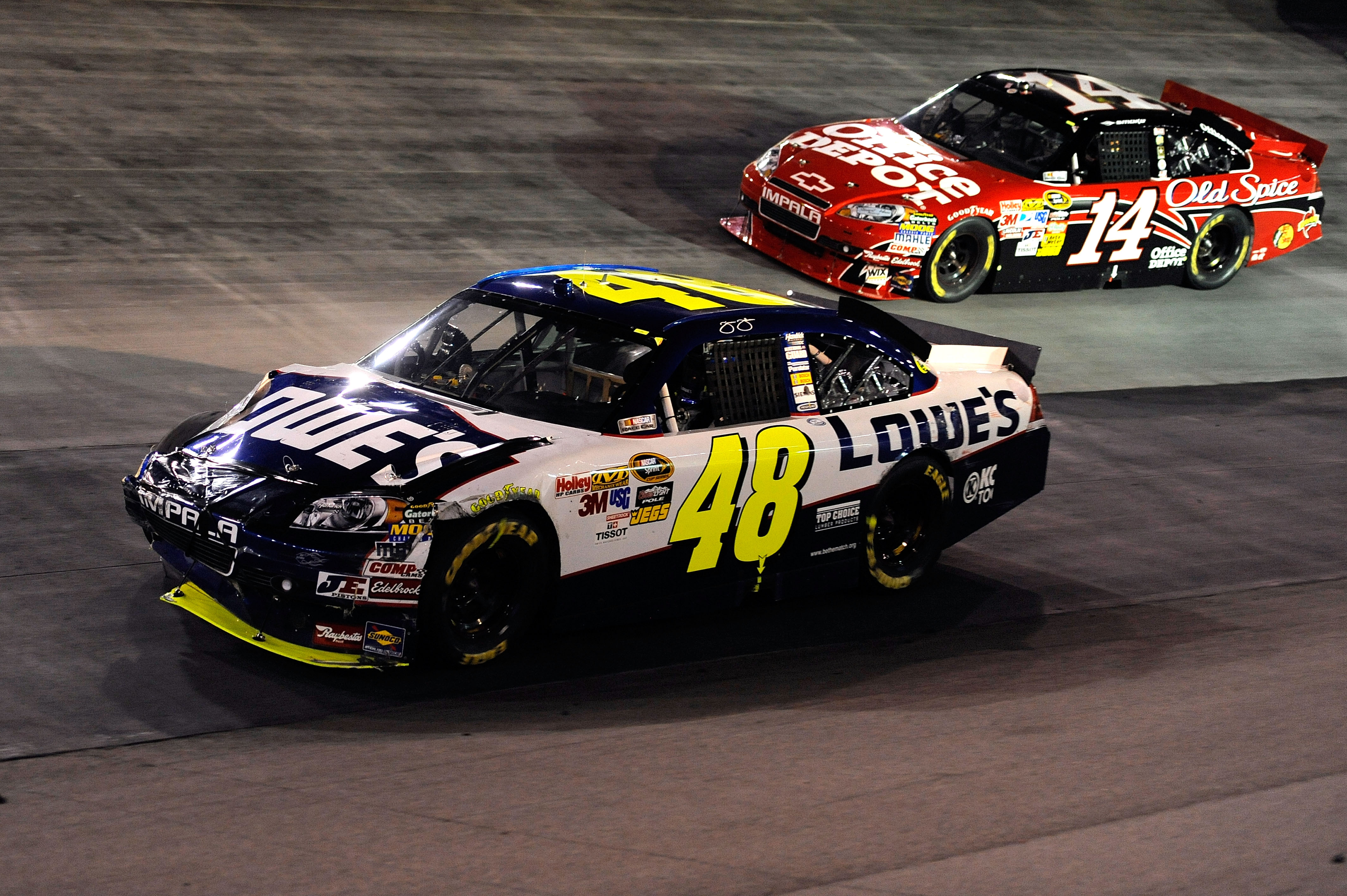 BRISTOL, TN - AUGUST 21:  Jimmie Johnson drives the #48 Lowe's Chevrolet down the aprin ahead of Tony Stewart, driver of the #14 Office Depot/Old Spice Chevrolet, after an incident on track in the NASCAR Sprint Cup Series IRWIN Tools Night Race at Bristol
