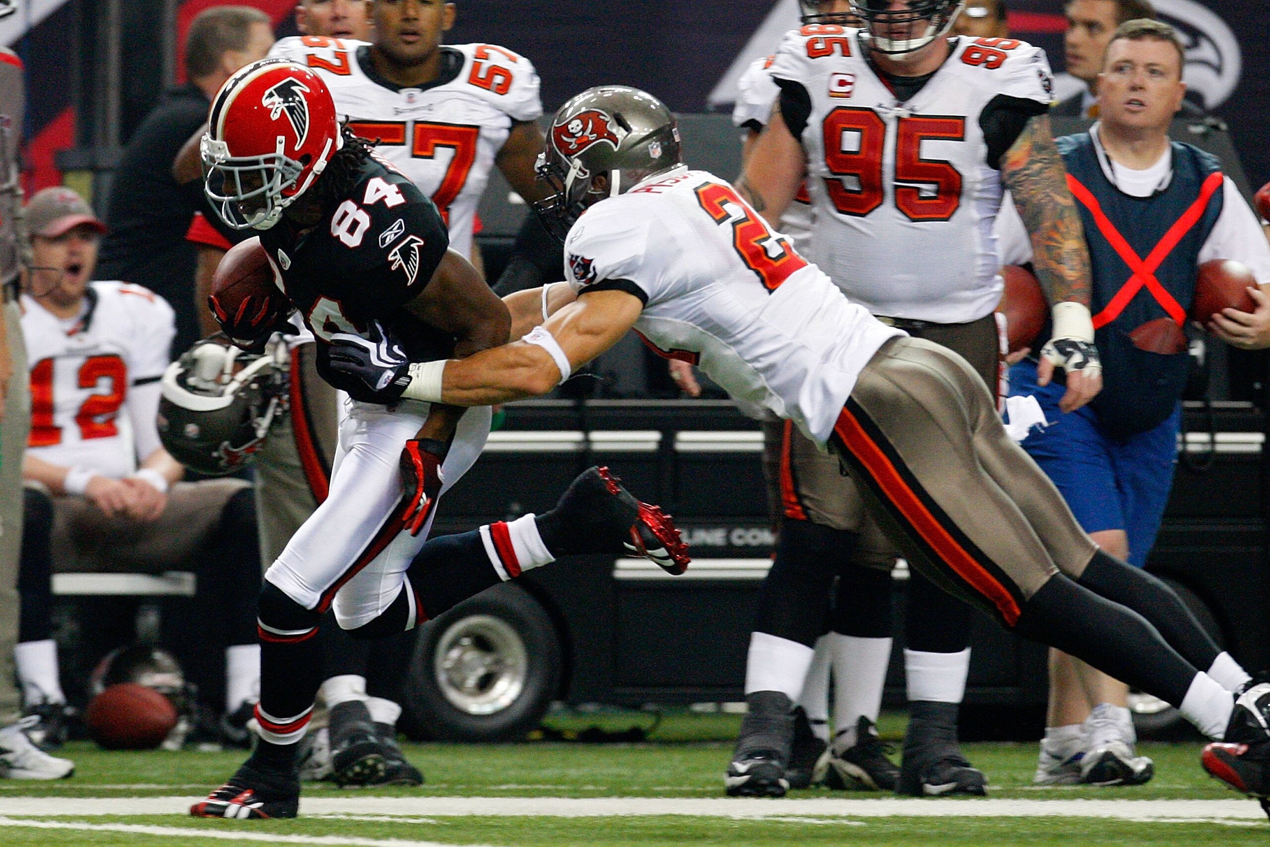 ATLANTA - NOVEMBER 29:  Roddy White #84 of the Atlanta Falcons breaks a tackle by Sabby Piscitelli #21 of the Tampa Bay Buccaneers at Georgia Dome on November 29, 2009 in Atlanta, Georgia.  (Photo by Kevin C. Cox/Getty Images)