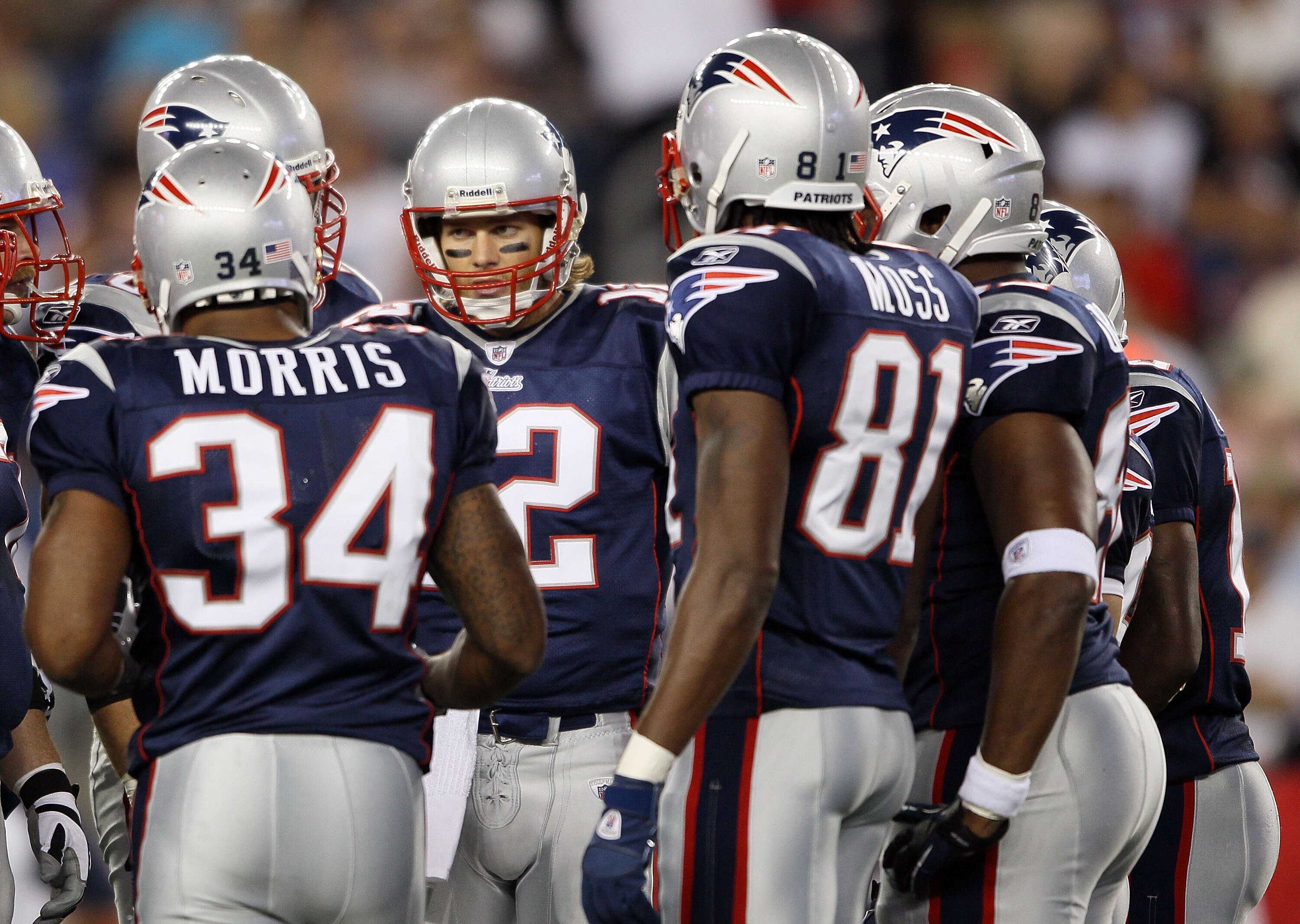 FOXBORO, MA - AUGUST 26:  Tom Brady #12 of the New England Patriots calls the play in the huddle as Sammy Morris #34 and Randy Moss #81 stand by in the first half against the St. Louis Rams on August 26, 2010 at Gillette Stadium in Foxboro, Massachusetts.