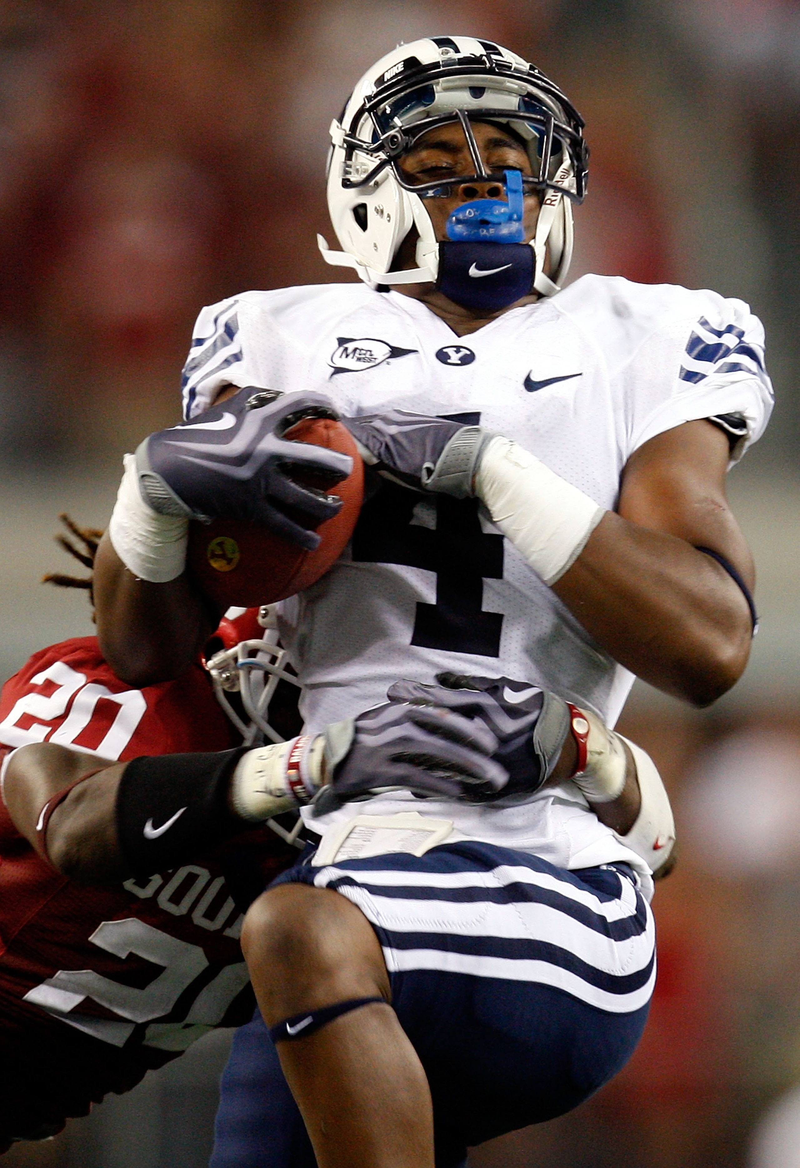 ARLINGTON, TX - SEPTEMBER 05:  Wide receiver O'Neill Chambers #4 of the Brigham Young Cougars makes a pass reception against Quinton Carter #20 of the Oklahoma Sooners at Cowboys Stadium on September 5, 2009 in Arlington, Texas.  (Photo by Ronald Martinez