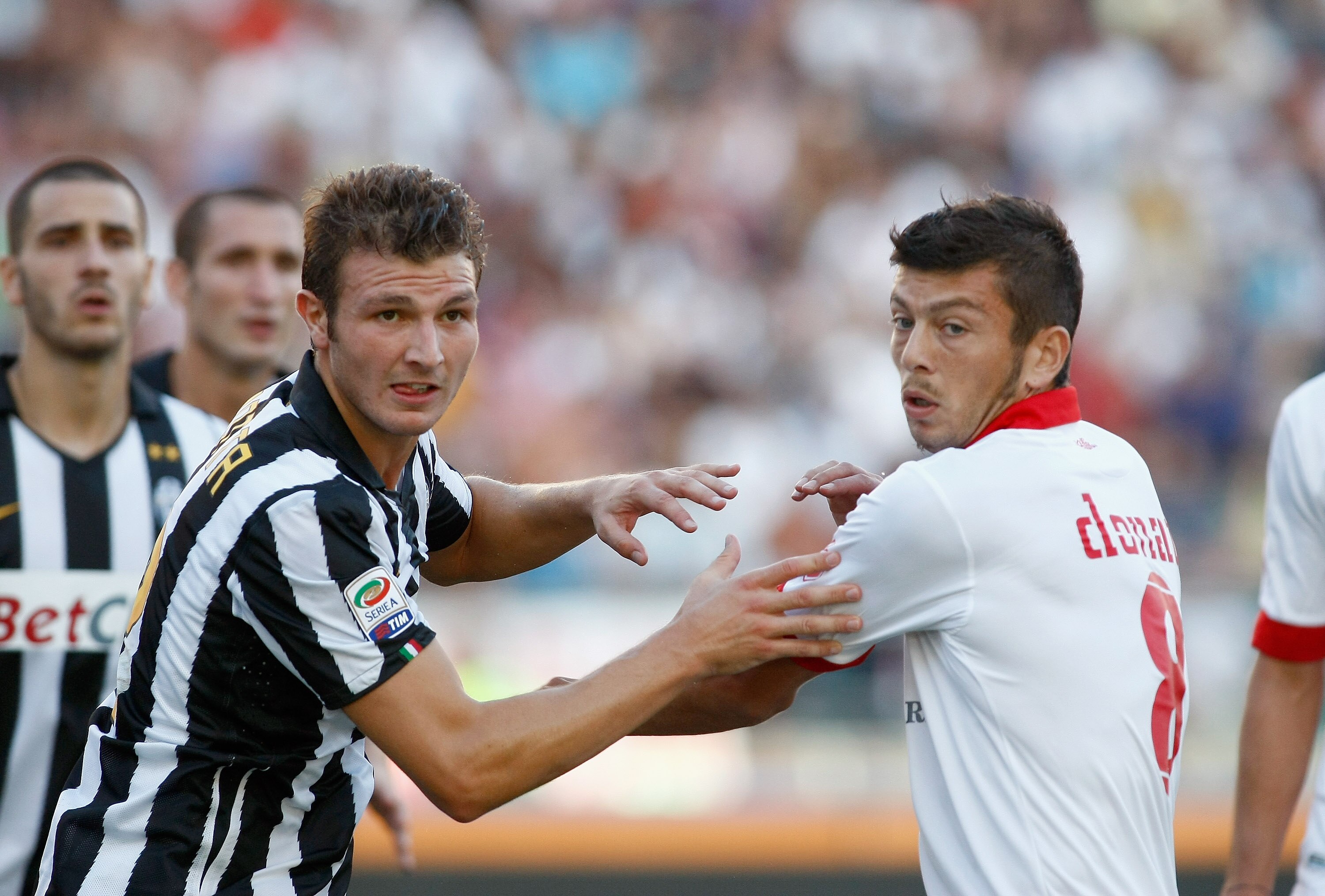 BARI, ITALY - AUGUST 29:  Marco Motta (L) of Juventus FC battles for the ball with Massimo Donati of AS Bari during the Serie A match between Bari and Juventus at Stadio San Nicola on August 29, 2010 in Bari, Italy.  (Photo by Maurizio Lagana/Getty Images