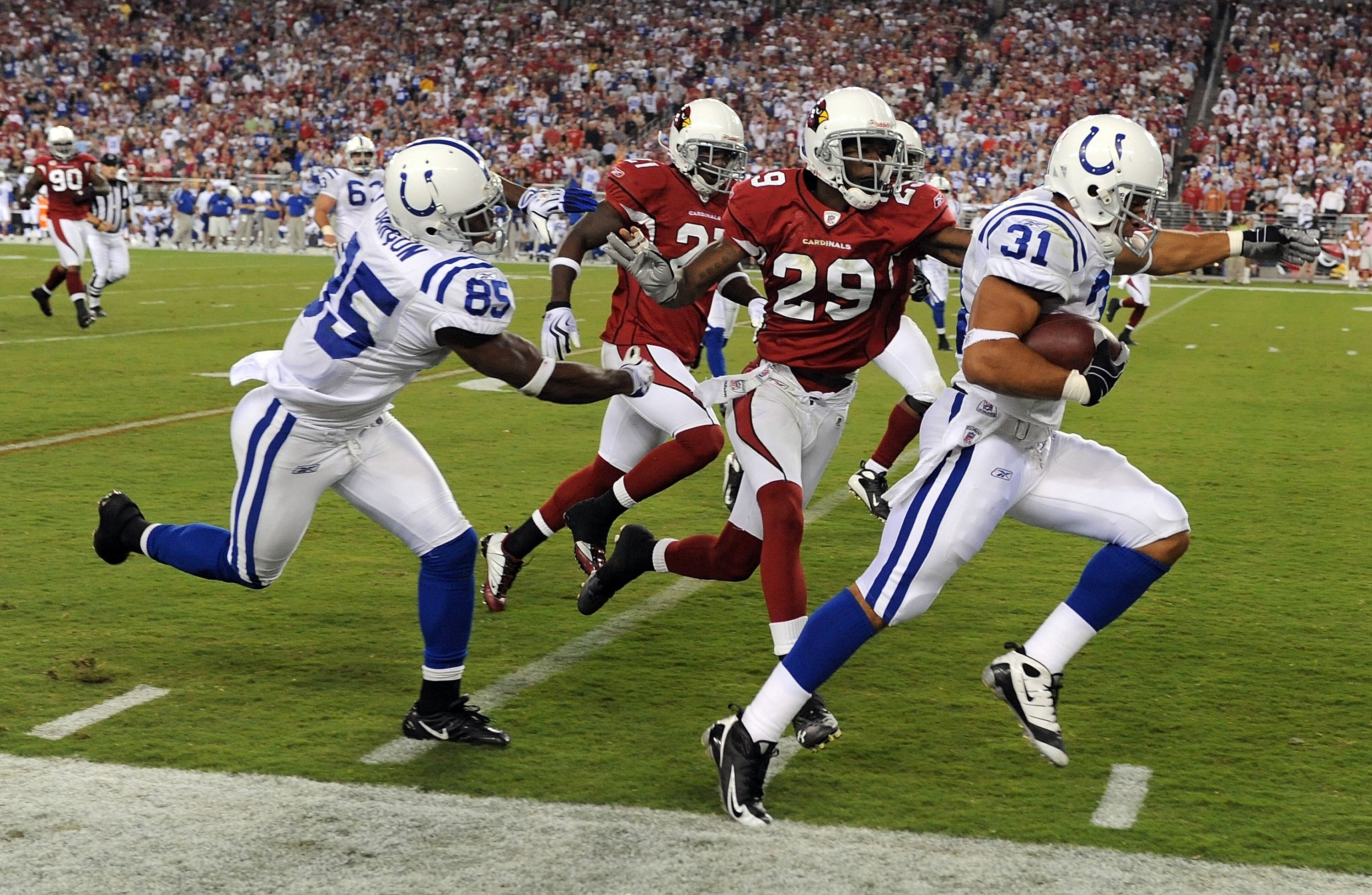 GLENDALE, AZ - SEPTEMBER 27:  Donald Brown #31 of the Indianapolis Colts steps out of bounds as he runs ahead of teammate Pierre Garcon #85,  Dominique Rodgers-Cromartie #29 and Antrel Rolle #21 of the Arizona Cardinals during the game at University of Ph