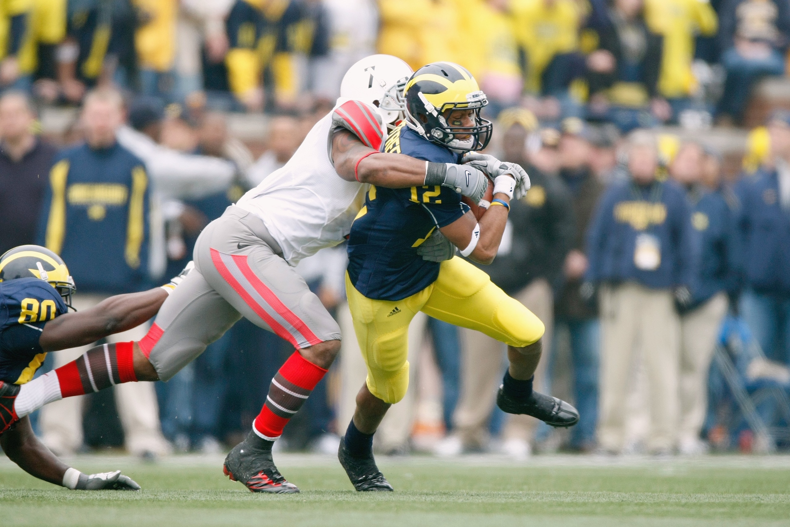 ANN ARBOR, MI - NOVEMBER 21: Roy Roundtree #12 of the Michigan Wolverines tries to get though the tackle of Jermale Hines #7 of the  Ohio State Buckeyes on November 21, 2009 at Michigan Stadium in Ann Arbor, Michigan. Ohio State won the game 21-10. (Photo