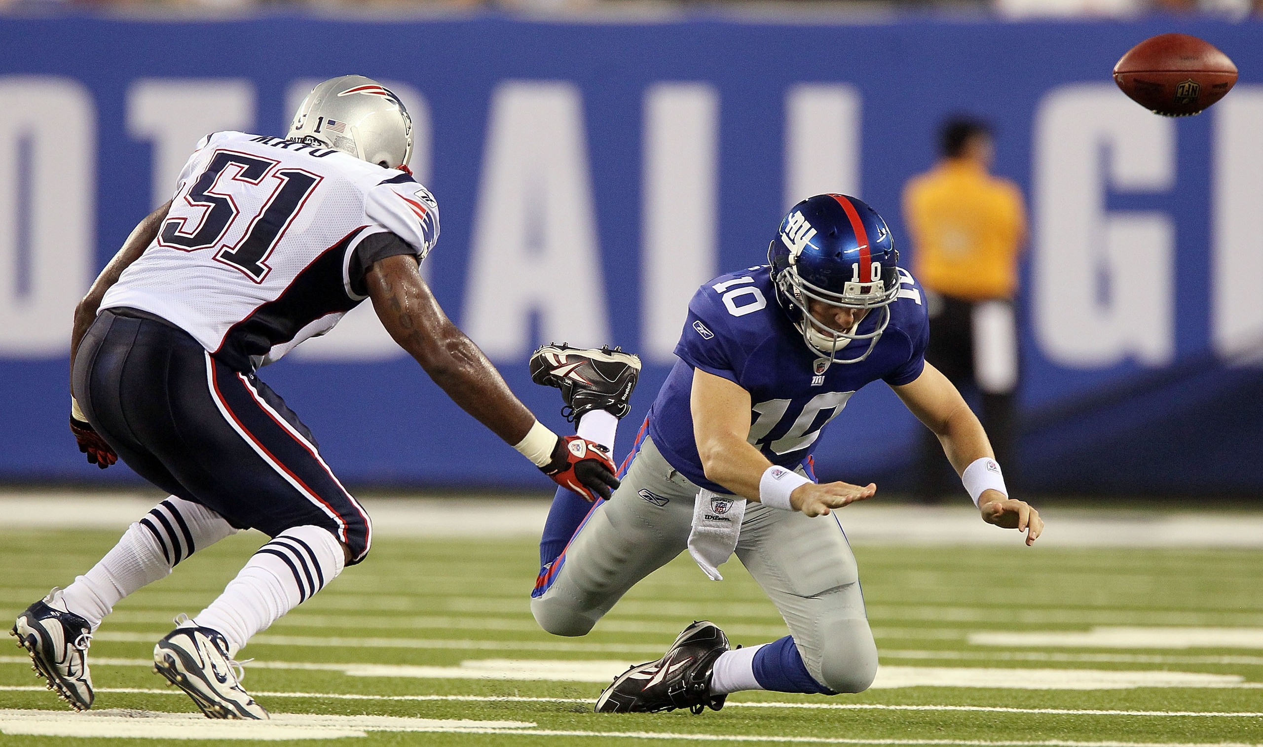 EAST RUTHERFORD, NJ - SEPTEMBER 02:  Eli Manning #10 of the New York Giants fumbles the ball in the first quarter as he is pressured by Jerod Mayo #51 of the New England Patriots on September 2, 2010 at the New Meadowlands Stadium in East Rutherford, New 