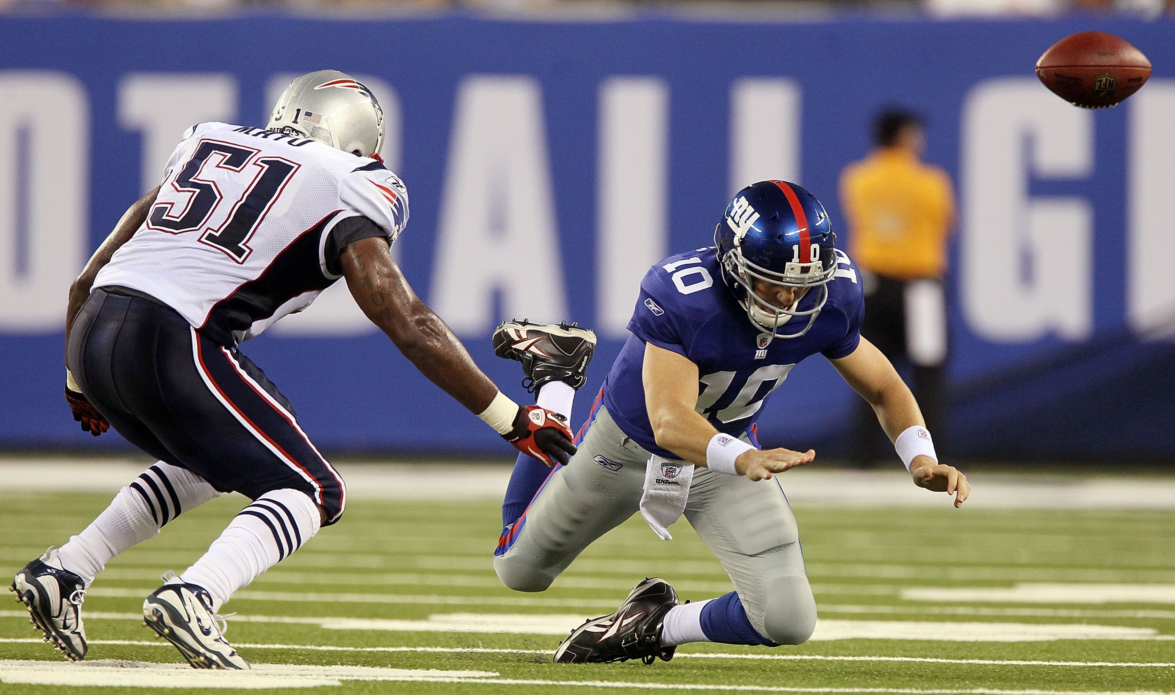 EAST RUTHERFORD, NJ - SEPTEMBER 02:  Eli Manning #10 of the New York Giants fumbles the ball in the first quarter as he is pressured by Jerod Mayo #51 of the New England Patriots on September 2, 2010 at the New Meadowlands Stadium in East Rutherford, New 
