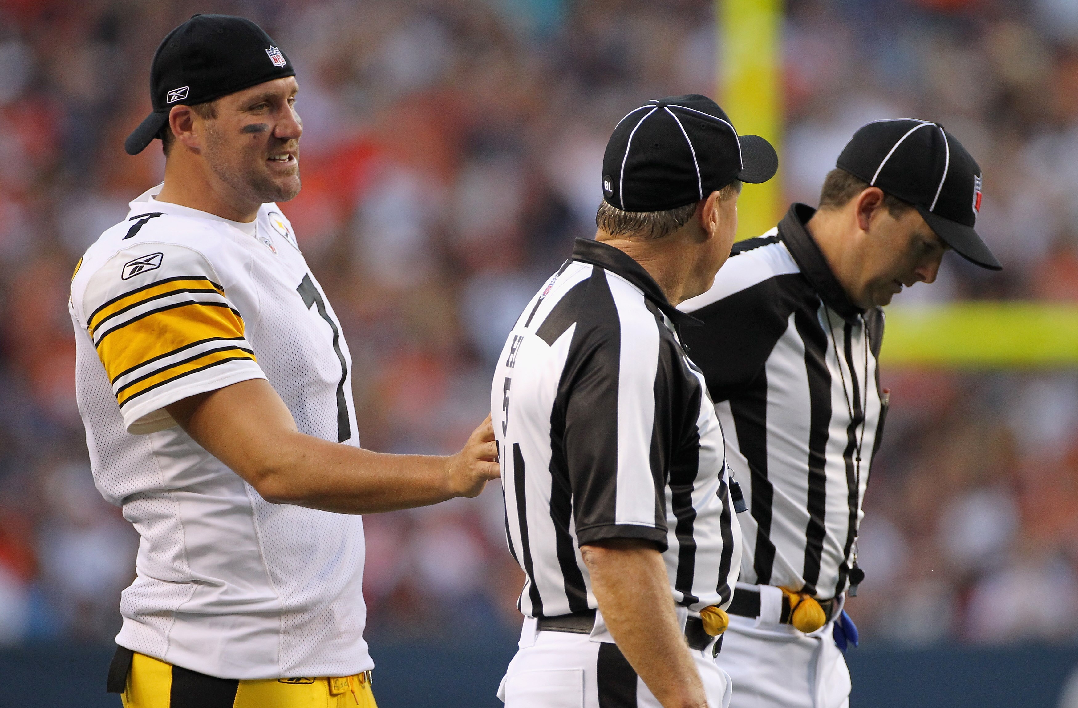 DENVER - AUGUST 29:  Quarterback Ben Rothlisberger #7 of the Pittsburgh Steelers talks with head linesman John McGrath (C) and side judge Allen Baynes (R) as the Steelers face the Denver Broncos during preseason NFL action at INVESCO Field at Mile High on