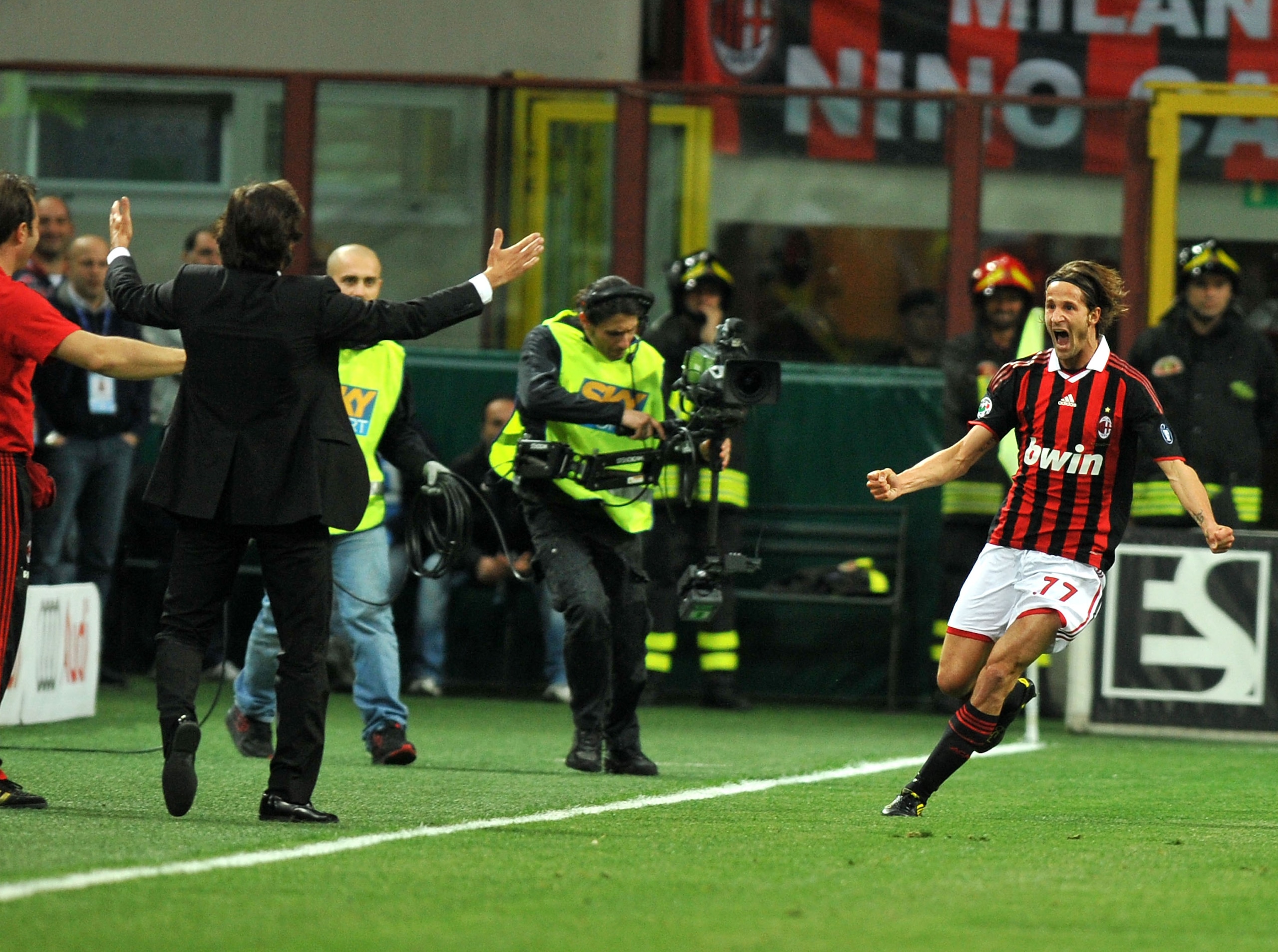MILAN, ITALY - MAY 15: Luca Antonini of AC Milan celebrates his opening goal running toward head coach Leonardo during the Serie A match between AC Milan and Juventus FC at Stadio Giuseppe Meazza on May 15, 2010 in Milan, Italy.  (Photo by Massimo Cebrell